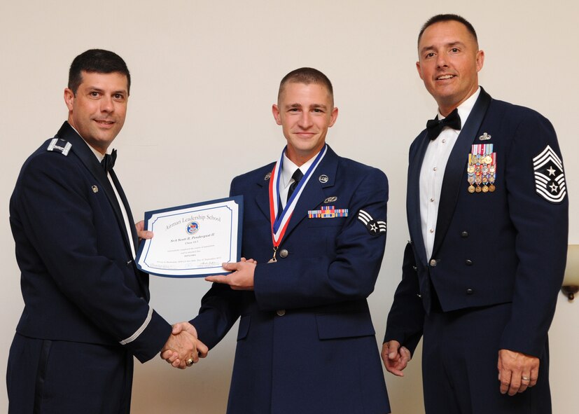 Senior Airman Scott Pendergast II, 2nd Civil Engineer Squadron, receives an Airman Leadership School graduation certificate from Col. Andrew Gebara, 2nd Bomb Wing commander, on Barksdale Air Force Base, La., Sept. 26, 2013. (U.S. Air Force photo)