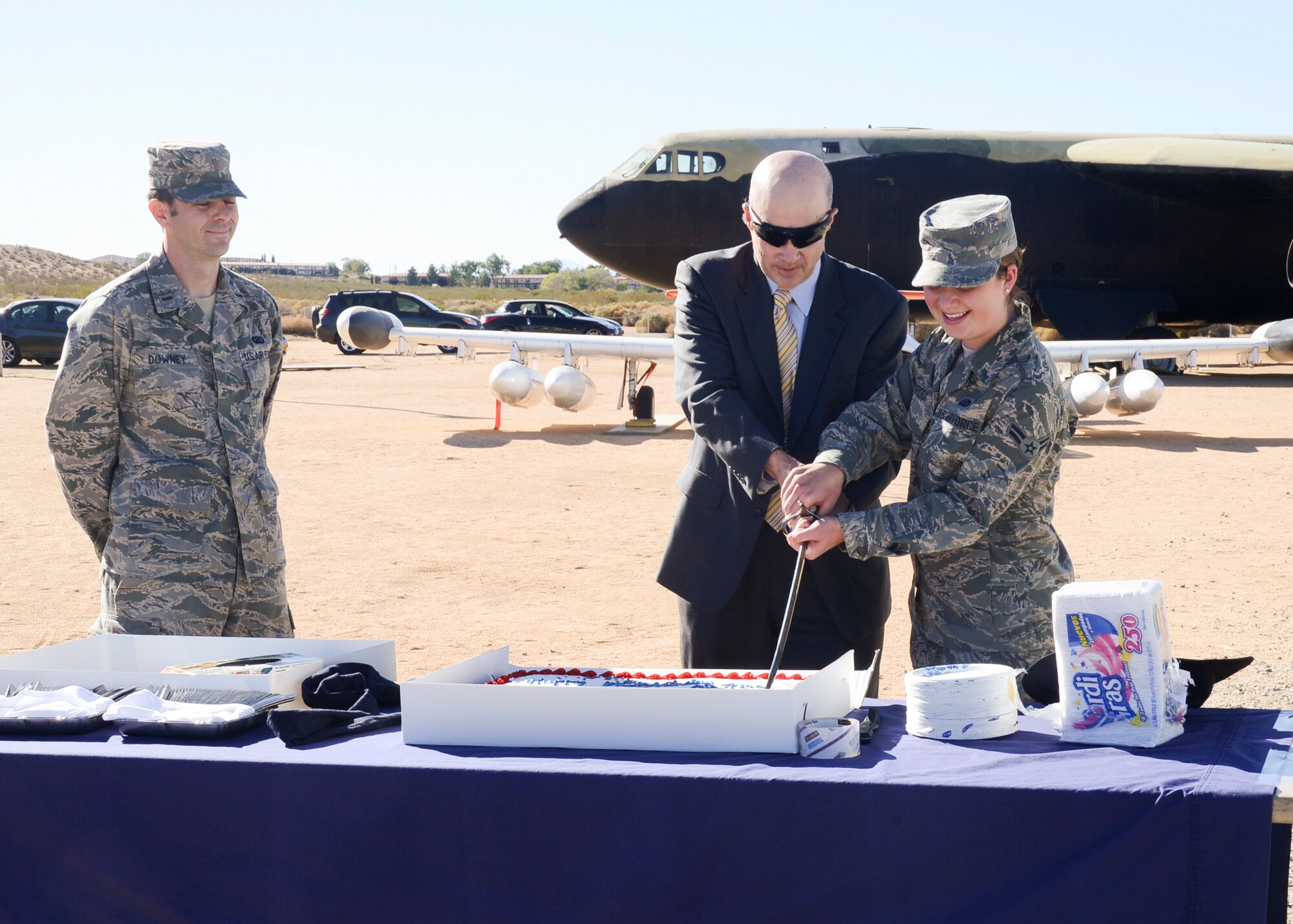 Following the Air Force song by the Edwards Singers, the oldest Airmen, James Judkins, 412th Civil Engineering Division director (center), and youngest Airmen, Airman First Class Alexis Tripodi (far right), 412th Force Support Squadron, cut the Air Force birthday cake at the Air Force Flight Test Museum Sept. 27. 2nd Lt. Jake Downey, Edwards Company Grade Officers Council president (left), coordinated the event. (U.S. Air Force photo by Rebecca Amber)