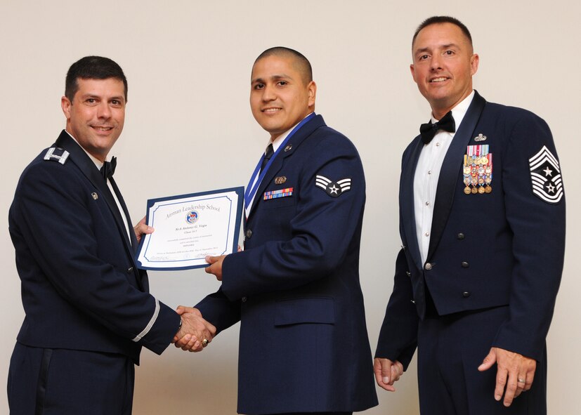 Senior Airman Anthony Vega, 2nd Communications Squadron, receives an Airman Leadership School graduation certificate from Col. Andrew Gebara, 2nd Bomb Wing commander, on Barksdale Air Force Base, La., Sept. 26, 2013. (U.S. Air Force photo)