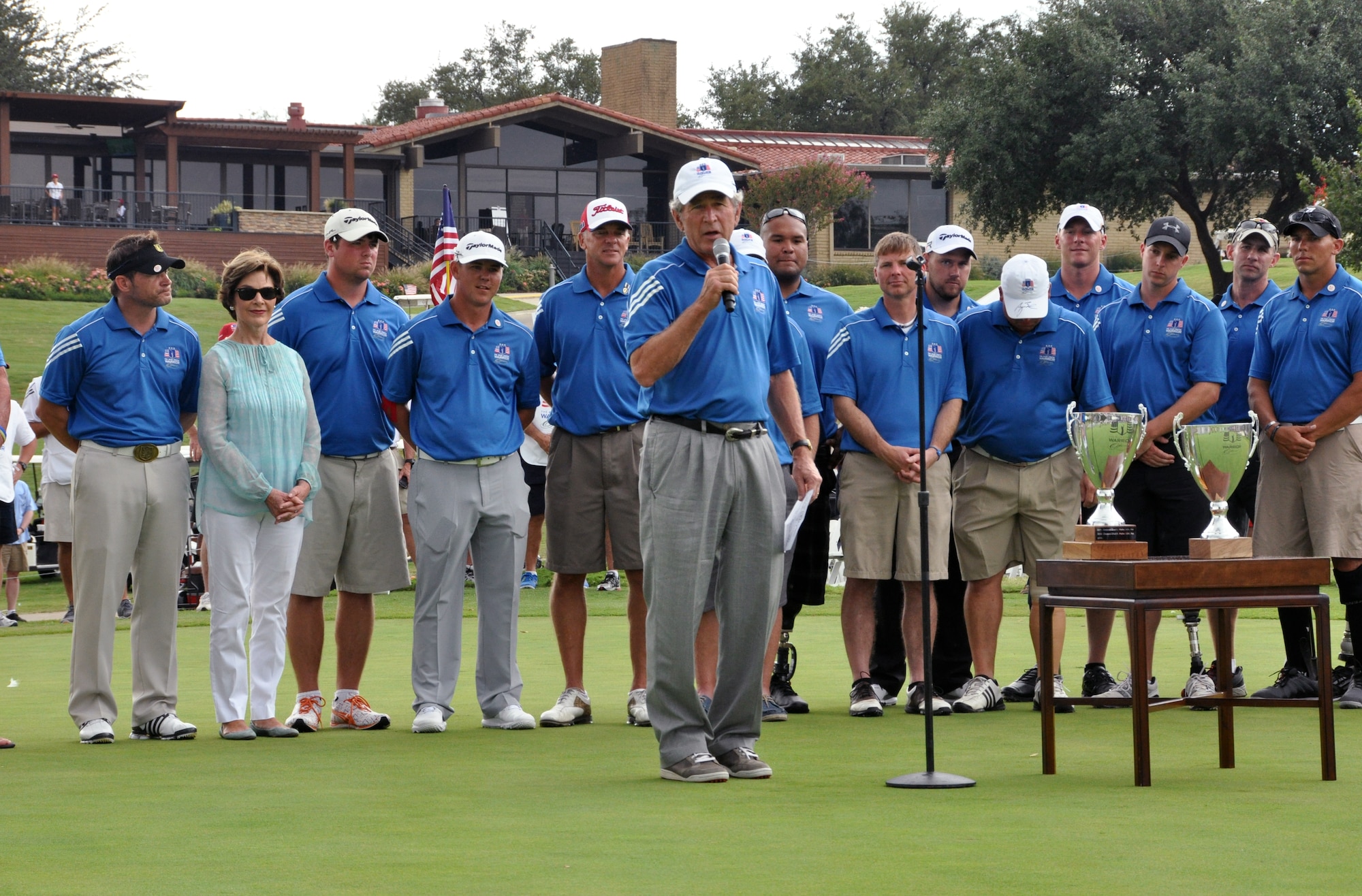 During the closing ceremonies at Las Collinas Country Country Club Golf Course, President Bush presented the Champion's Cup to Corporal Chad Pfeifer and the Warrior Cup to Staff Sargeant Benjamin Dellinger and Captain Matthew Anderson ending the 2013 Warrior Open and just before it poured rain. Eighteen wounded warriors from the Air Force, Army and Marines joined in a competitive two-day, 36-hole golf tournament that kicked off Sept. 26, 2013, to honor post-9/11 U.S. service members wounded in the global war on terror. (U.S. Air Force photo/MSgt Julie Briden-Garcia)