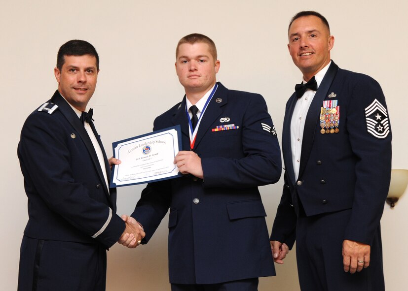 Senior Airman Ernest Graff, 2nd Maintenance Squadron, receives an Airman Leadership School graduation certificate from Col. Andrew Gebara, 2nd Bomb Wing commander, on Barksdale Air Force Base, La., Sept. 26, 2013. (U.S. Air Force photo)