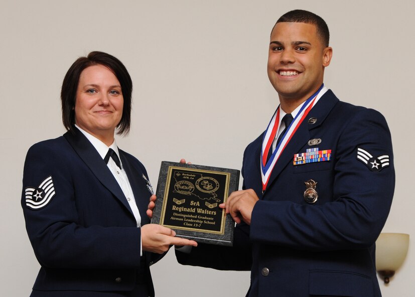 Senior Airman Reginald Walters, 2nd Security Forces Squadron, receives the Distinguished Graduate Award from Tech. Sgt. Joelle Silny, Air Force Global Strike Command, on behalf of the Air Force Sergeants Association during the Airman Leadership School Class 13-7 Graduation on Barksdale Air Force Base, La., Sept. 26, 2013. (U.S. Air Force photo)