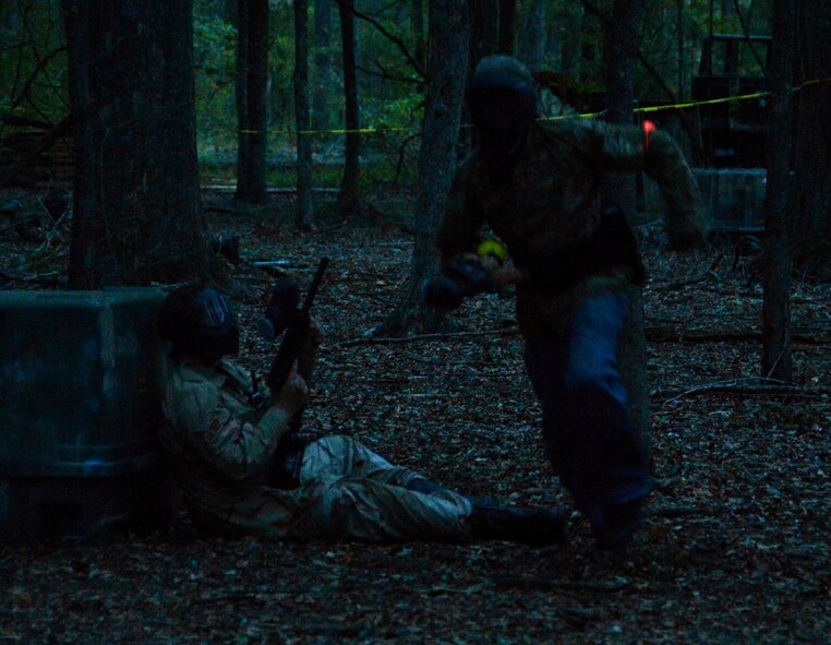 A human runs for nearby cover as another hides during the Zombie Apocalypse paintball game on Barksdale Air Force Base, La., Sept. 28, 2013. Before the game, more than 100 Team Barksdale members chose whether to be a human-hunting zombie or a human trying to survive the invasion. (U.S. Air Force photo/Staff Sgt. Amber Corcoran)