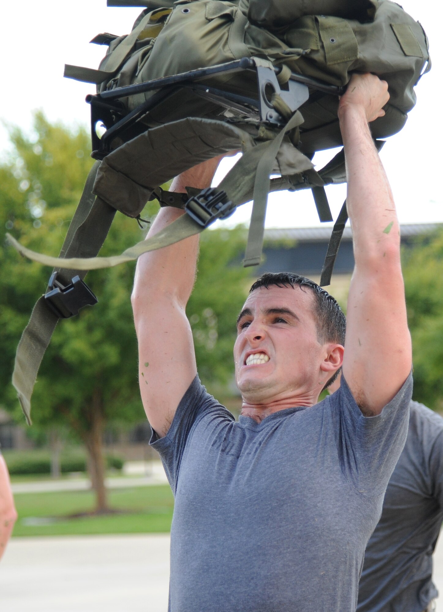 Airman 1st Class Evan Jensen, 334th Training Squadron combat controller student, performs ruck presses during a memorial physical training session with members of the 334th Training Squadron combat controllers and the 335th Training Squadron special operations weather team Sept. 27, 2013, at Keesler Air Force Base, Miss.  The PT event was in memory of combat controller Senior Airman Mark Forester who was killed in action on Sept. 29, 2010. (U.S. Air Force photo by Kemberly Groue)