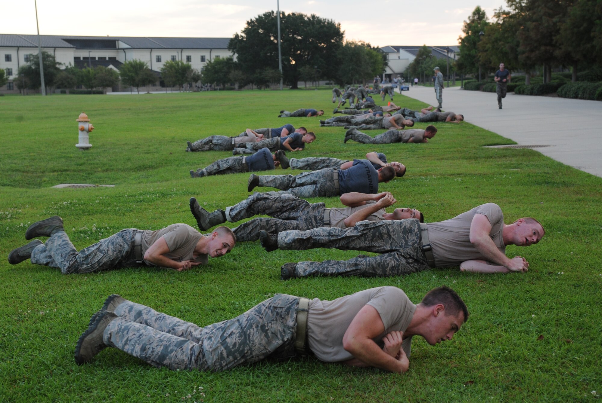 Members of the 334th Training Squadron combat controllers and the 335th Training Squadron special operations weather team do a log roll exercise during a memorial physical training session Sept. 27, 2013, at Keesler Air Force Base, Miss.  The PT event was in memory of combat controller Senior Airman Mark Forester who was killed in action on Sept. 29, 2010. (U.S. Air Force photo by Kemberly Groue)
