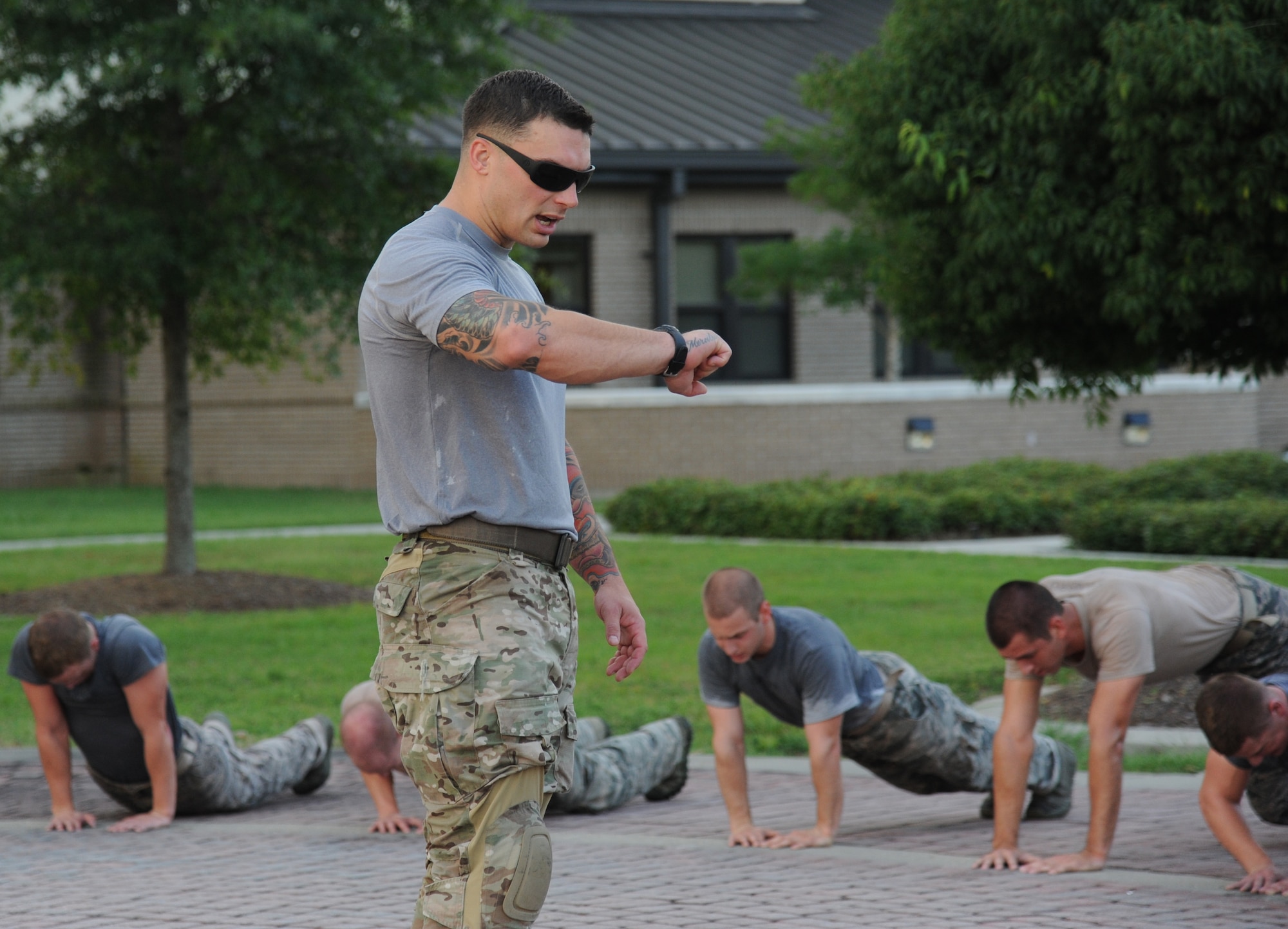 Tech. Sgt. Yuri Miller, 334th Training Squadron combat controller instructor, hurries members of the 334th Training Squadron combat controllers and the 335th Training Squadron special operations weather team as they do push-ups during a memorial physical training session Sept. 27, 2013, at Keesler Air Force Base, Miss.  The PT event was in memory of combat controller Senior Airman Mark Forester who was killed in action on Sept. 29, 2010. (U.S. Air Force photo by Kemberly Groue)
