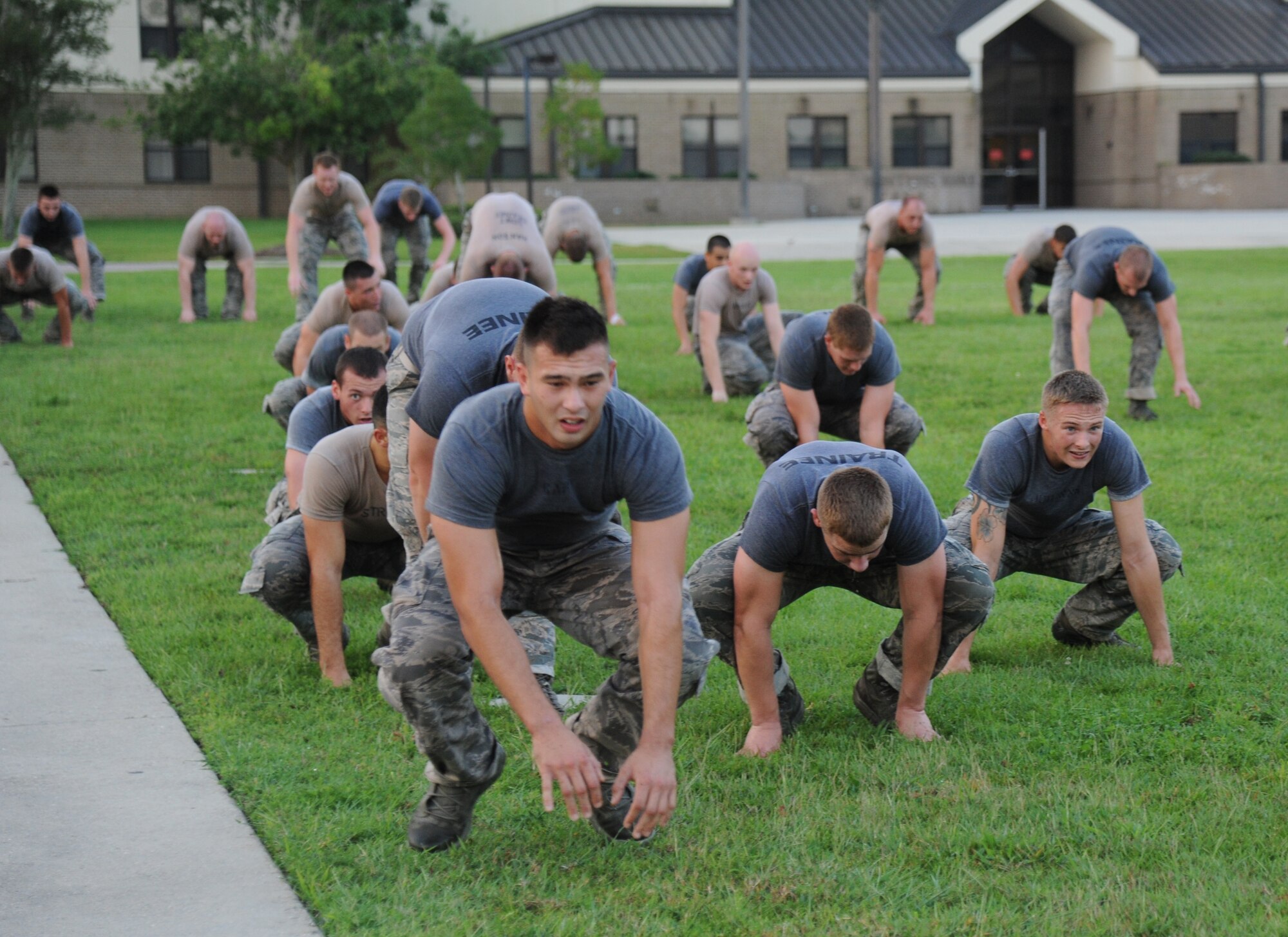 Members of the 334th Training Squadron combat controllers and the 335th Training Squadron special operations weather team do ”leap frogs” during a memorial physical training session Sept. 27, 2013, at Keesler Air Force Base, Miss.  The PT event was in memory of combat controller Senior Airman Mark Forester who was killed in action on Sept. 29, 2010. (U.S. Air Force photo by Kemberly Groue)