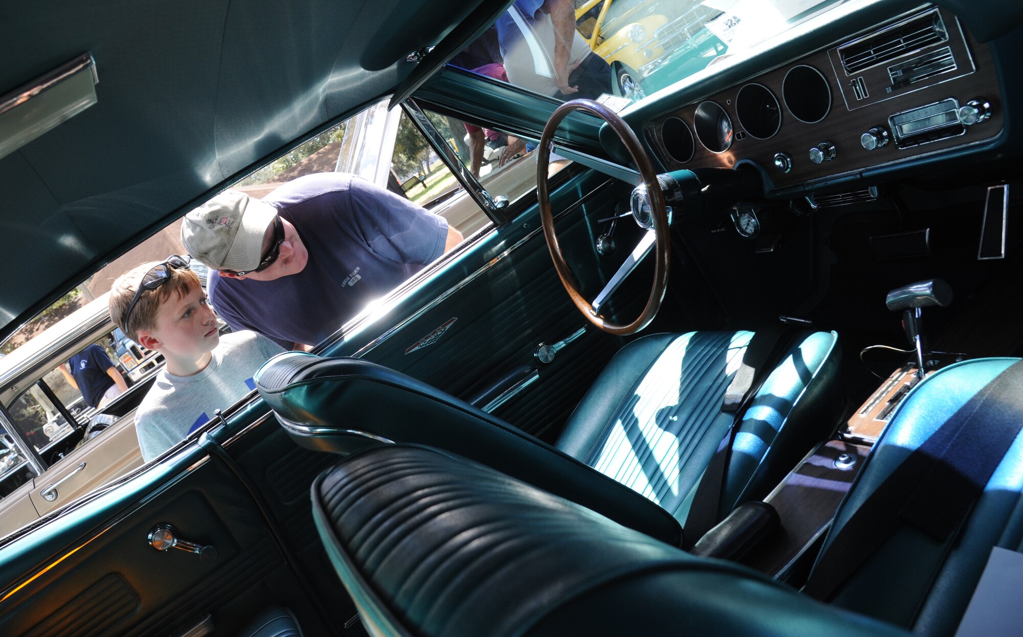 Senior Master Sgt. Craig Edwards, 81st Training Support Squadron, and his son examine the inside of a 1967 Pontiac GTO during the Cruisin’ Keesler 10th Annual Car Show on Sept. 28, 2013, at Keesler Air Force Base, Miss. (U.S. Air Force photo by Kemberly Groue)