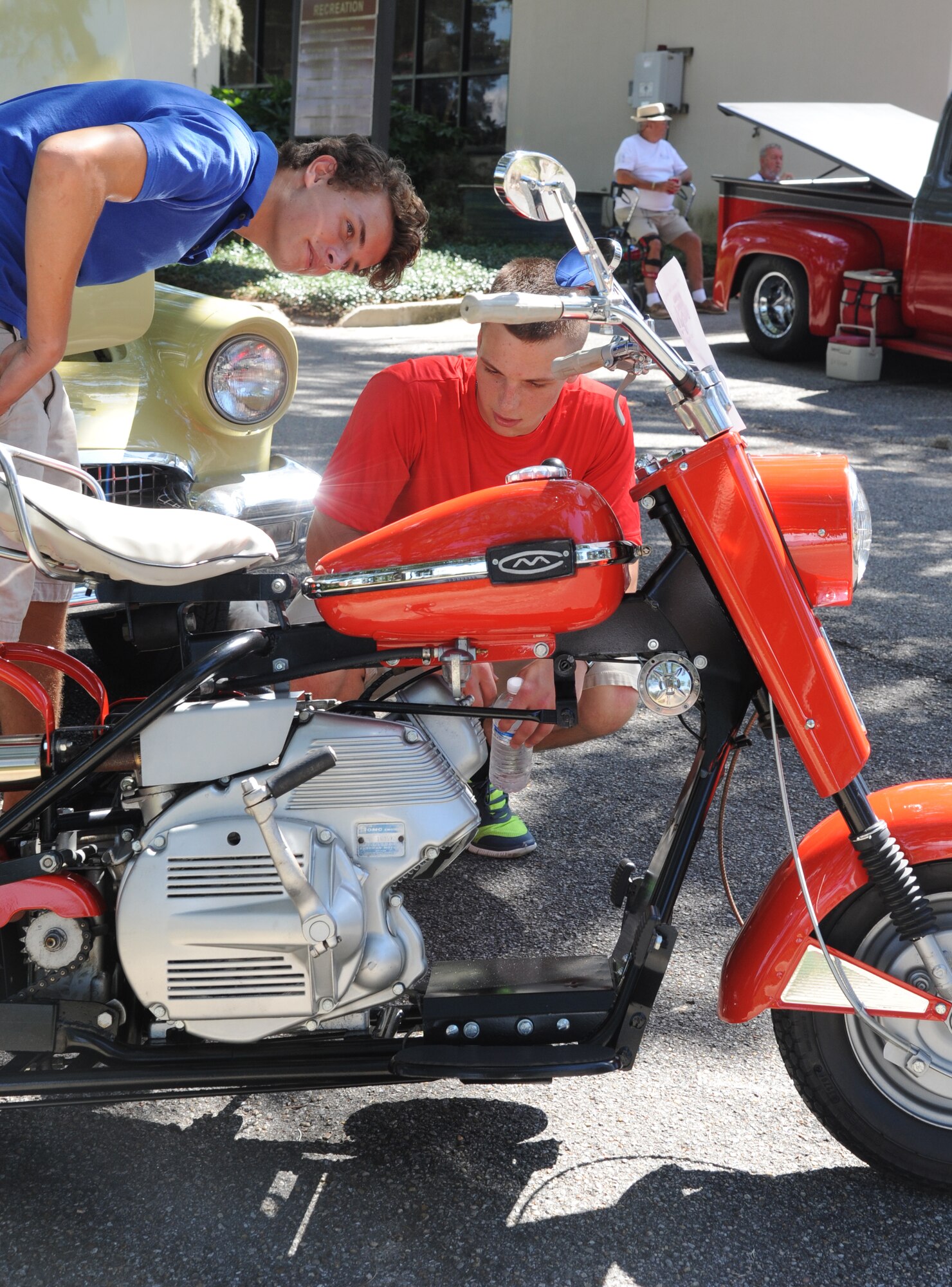 Austin Rafferty, 81st Force Support Squadron, and Airman Basic Weston Lysyczyn, 336th Training Squadron, examine a 1963 Cushman Eagle motorcycle during the Cruisin’ Keesler 10th Annual Car Show on Sept. 28, 2013, at Keesler Air Force Base, Miss. (U.S. Air Force photo by Kemberly Groue)
