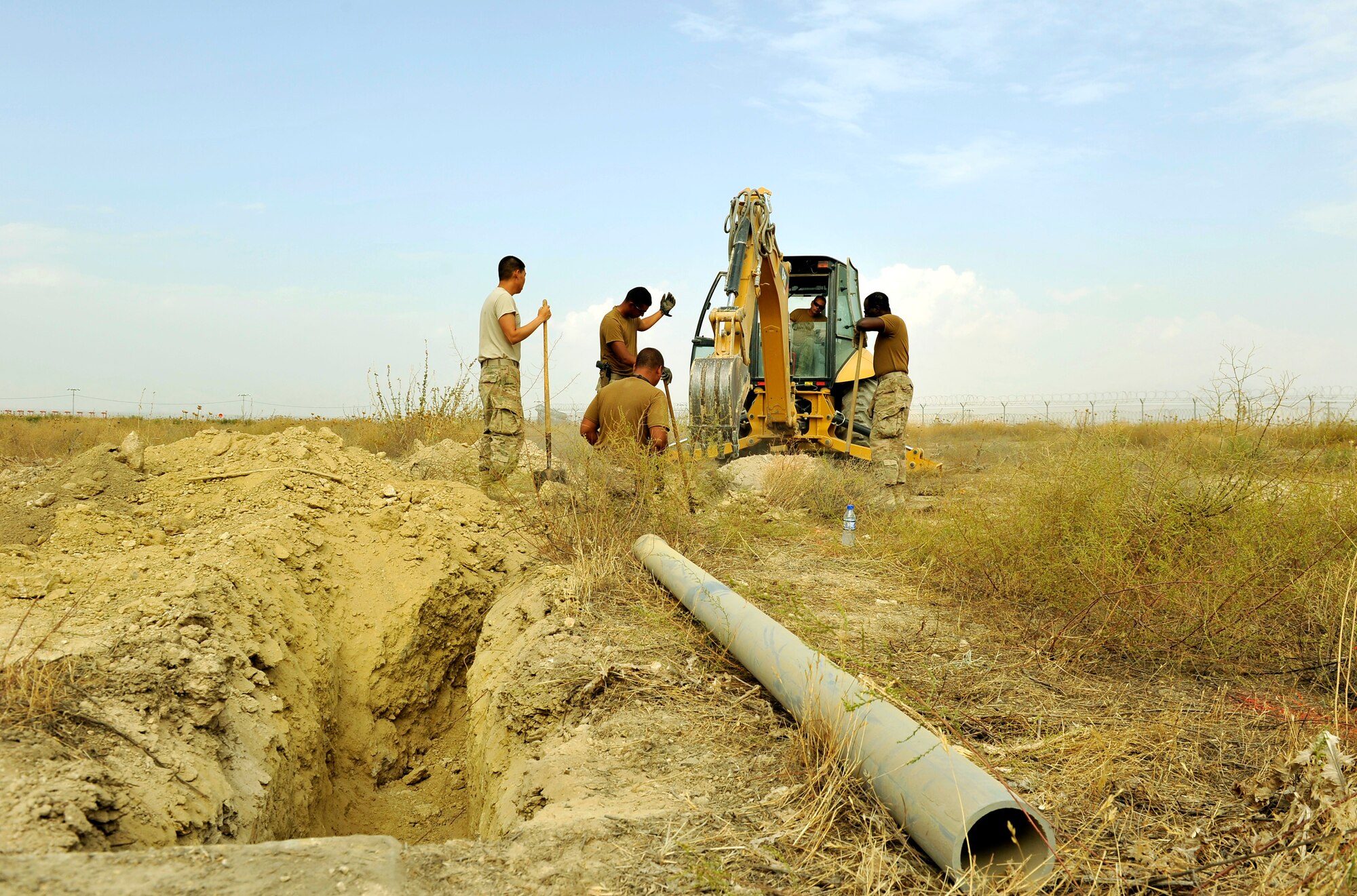 Five Airmen assigned to the 455th Expeditionary Communications Squadron engineering and installation team dig a trench prior to installing fiber cable for the new weather observation system on Bagram Airfield, Afghanistan, Sept. 12. The system is the first to be installed in the area of responsibility and will help the base determine more accurate weather forecast. The Airmen are forward deployed here from 9th Air Force, Al Udeid Air Base, Qatar. (U.S. Air Force Photo/ Staff Sgt. Stephenie Wade)