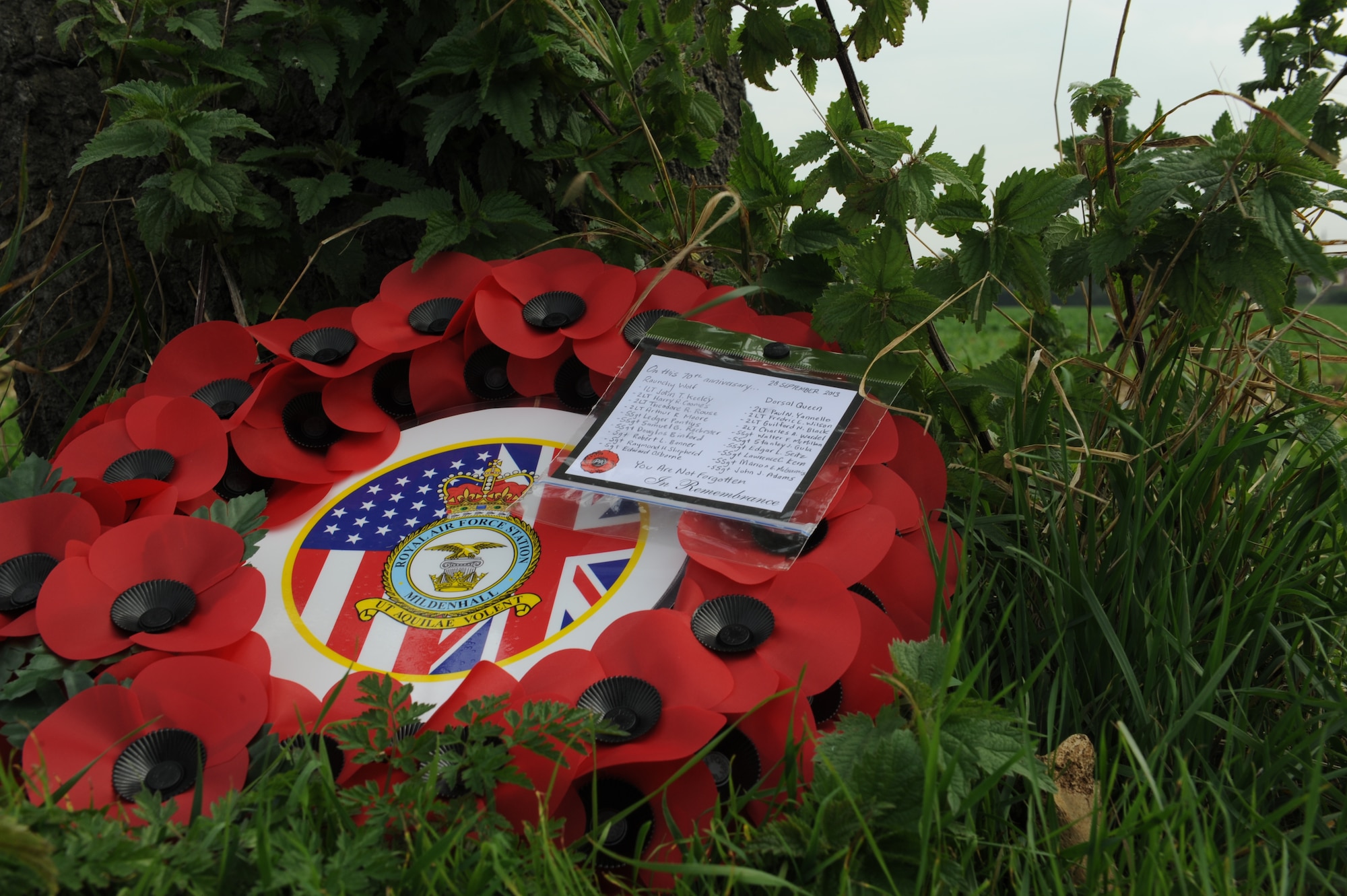 U.S. Air Force Col. Nancy Bozzer, 100th Operations Group commander, laid a wreath Sept. 28, 2013, against the tree that marks the crash-landing location of the Dorsal Queen, a B-17 Flying Fortress. After a ceremony commemorating the 70th anniversary of the Sept. 26, 1943, collision involving two B-17s, Bozzer, along with several other Team Mildenhall Airmen, traveled to the crash site to pay respect to the deceased. Out of the 20 service members on board the two aircraft, only one tail gunner survived. (U.S. Air Force photo by Airman 1st Class Preston Webb/Released)
