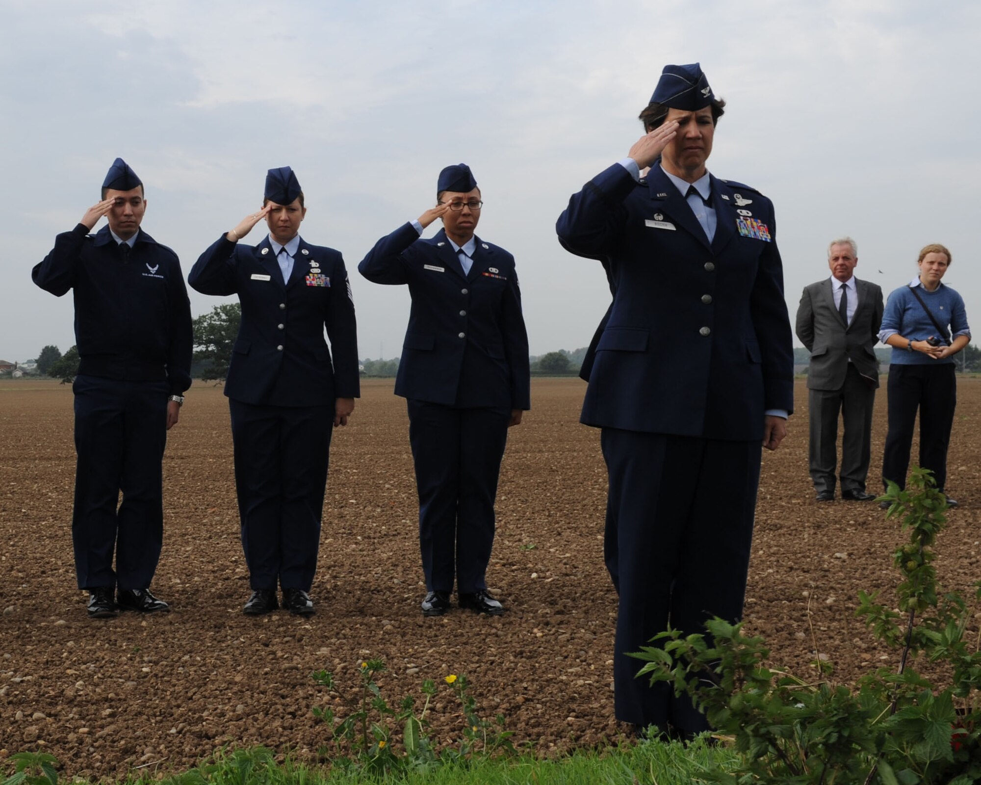 U.S. Air Force Col. Nancy Bozzer, front, 100th Operations Group commander, and several Team Mildenhall Airmen salute the crash site of the Dorsal Queen, a B-17 Flying Fortress. Two B-17s — Dorsal Queen and Raunchy Wolf — collided in mid-air while returning from a bombing mission during World War II. Out of the 20 service members on board the two aircraft, only one tail gunner survived.  (U.S. Air Force photo by Airman 1st Class Preston Webb/Released)
