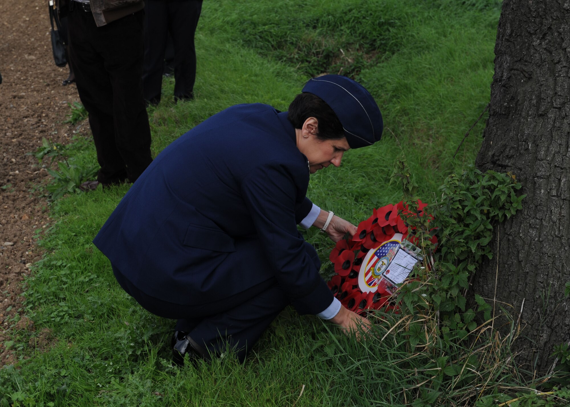 U.S. Air Force Col. Nancy Bozzer, 100th Operations Group commander, lays a wreath at the base of a tree Sept. 28, 2013, where the Dorsal Queen, a B-17 Flying Fortress, crash landed after colliding with the Raunchy Wolf, another B-17 Flying Fortress,  Sept. 26, 1943. After a ceremony commemorating the 70th anniversary of the collision of the two B-17s, Bozzer, along with several other Team Mildenhall Airmen, traveled to the crash site to lay a wreath and pay respect to the deceased. Out of the 20 service members onboard the two aircraft, only one tail gunner survived. (U.S. Air Force photo by Airman 1st Class Preston Webb/Released)
