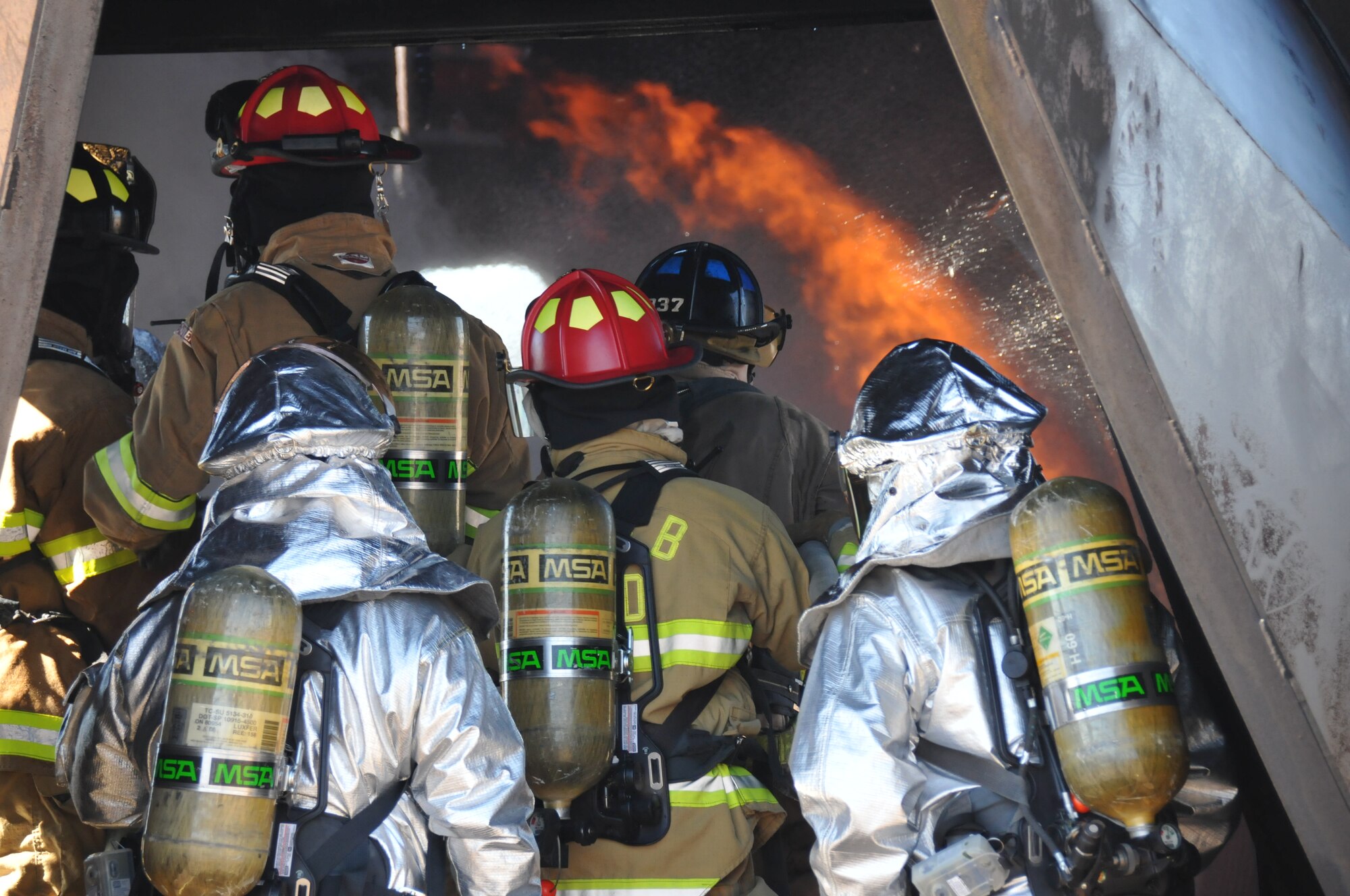 Members of the 377th Civil Engineer Squadron's firefighting unit practice skills on a burning aircraft during a training exercise Sept. 20. Personnel assigned to the fire department must achieve at least two aircraft live-fire trainings each year. (Photo by Ken Moore)