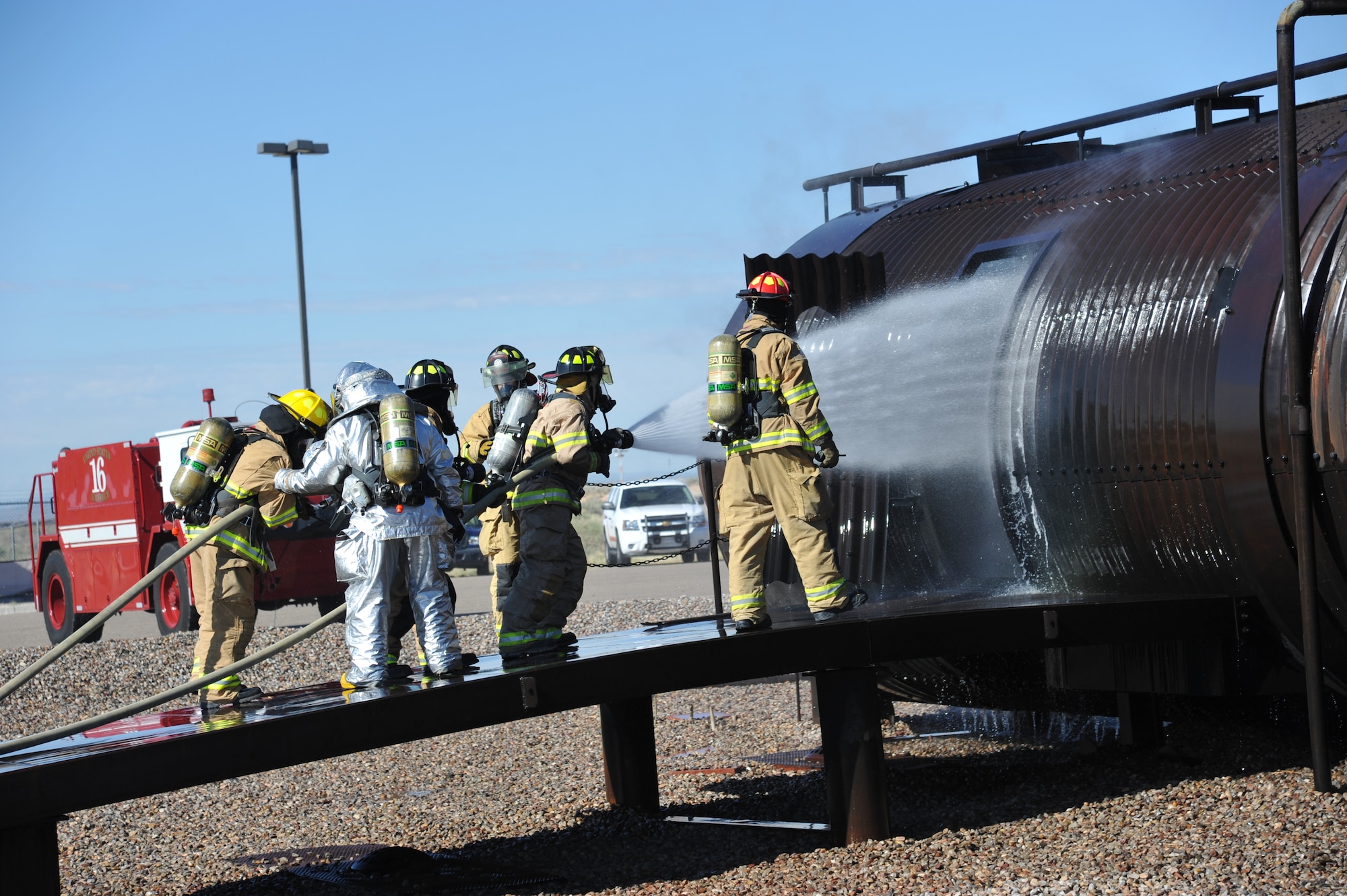 Members of the 377th Civil Engineer Squadron's firefighting unit practice skills on a burning aircraft during a training exercise Sept. 20. Personnel assigned to the fire department must achieve at least two aircraft live-fire trainings each year. (Photo by Ken Moore)