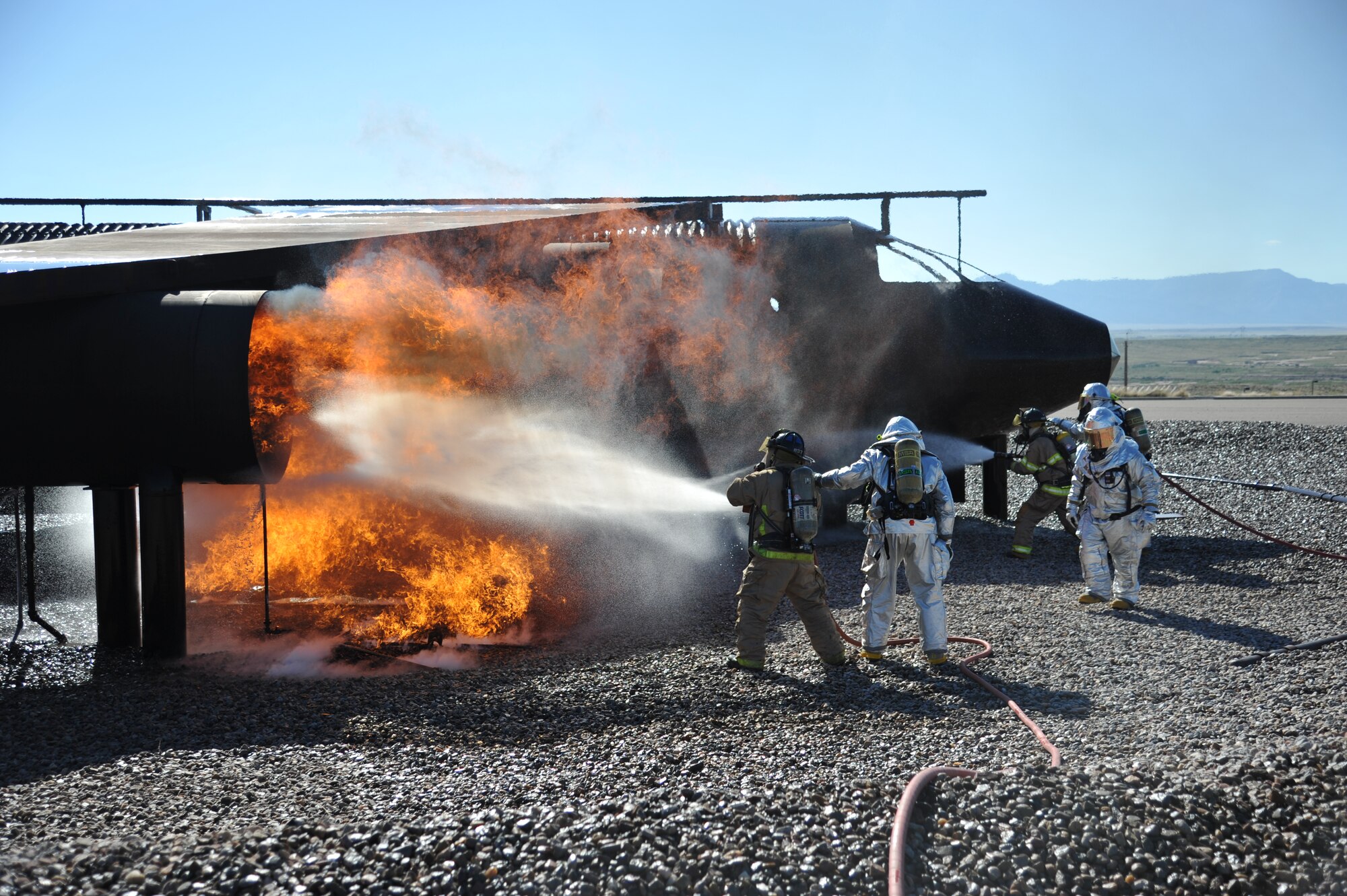 Members of the 377th Civil Engineer Squadron's firefighting unit practice skills on a burning aircraft during a training exercise Sept. 20. Personnel assigned to the fire department must achieve at least two aircraft live-fire trainings each year. (Photo by Ken Moore)