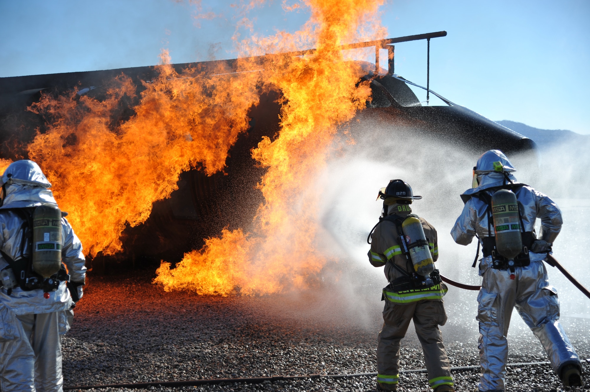 Members of the 377th Civil Engineer Squadron's firefighting unit practice skills on a burning aircraft during a training exercise Sept. 20. Personnel assigned to the fire department must achieve at least two aircraft live-fire trainings each year. (Photo by Ken Moore)