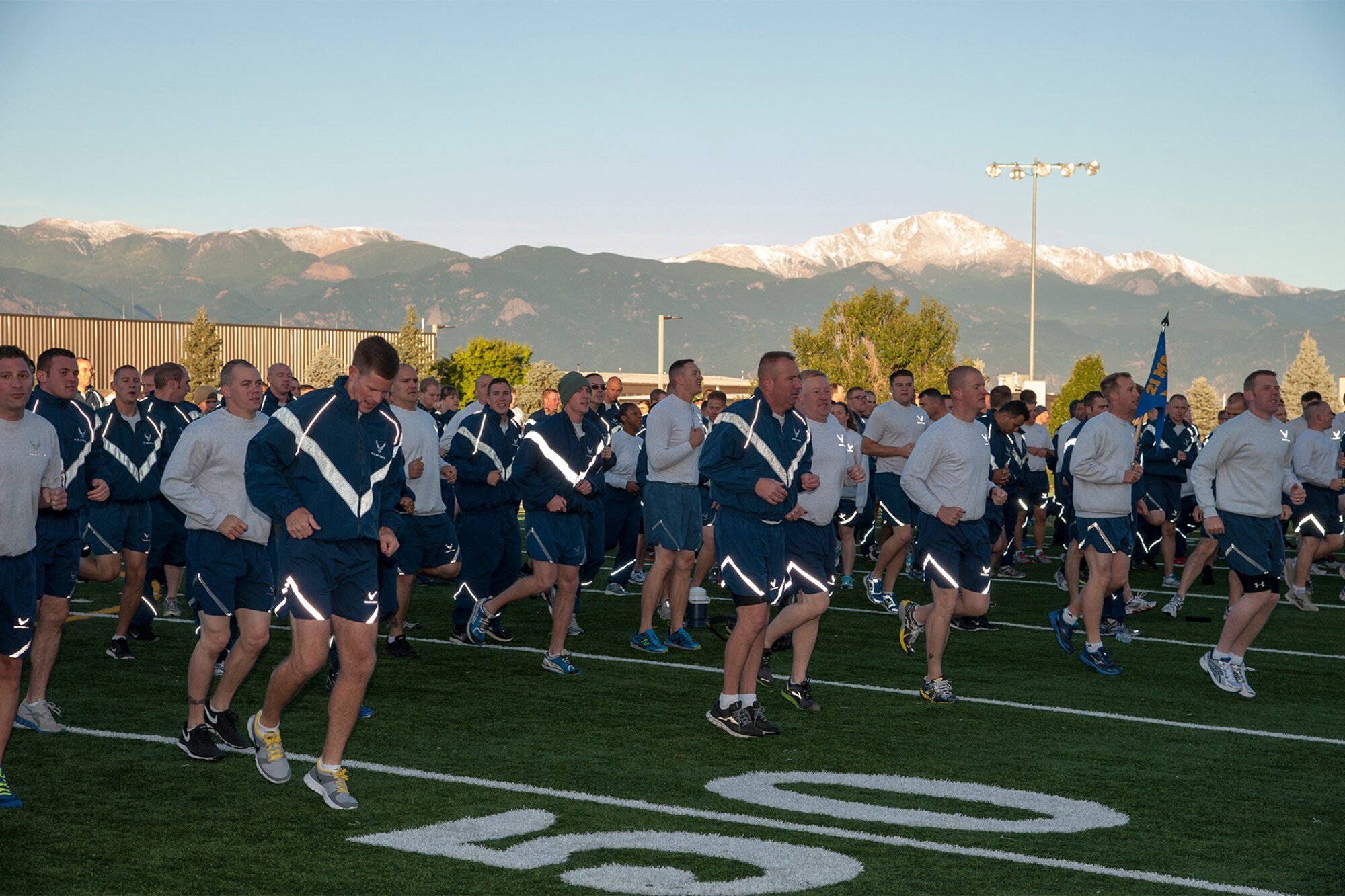 PETERSON AIR FORCE BASE, Colo. – With Pikes Peak in the background, the 21st Space Wing began its monthly Wing Warfit early Sept. 24 behind the fitness center. Chief Master Sgt. Douglas McIntyre, Headquarters Air Force Space Command command chief, spoke about being a world champion Air Force. Airmen then warmed up before racing off to a 5K Fun Run, concluding at The Club for the annual CFC kickoff. The wing holds the monthly warfit to increase cohesion and camaraderie among the Airmen. (U.S. Air Force photo/Philip Carter)