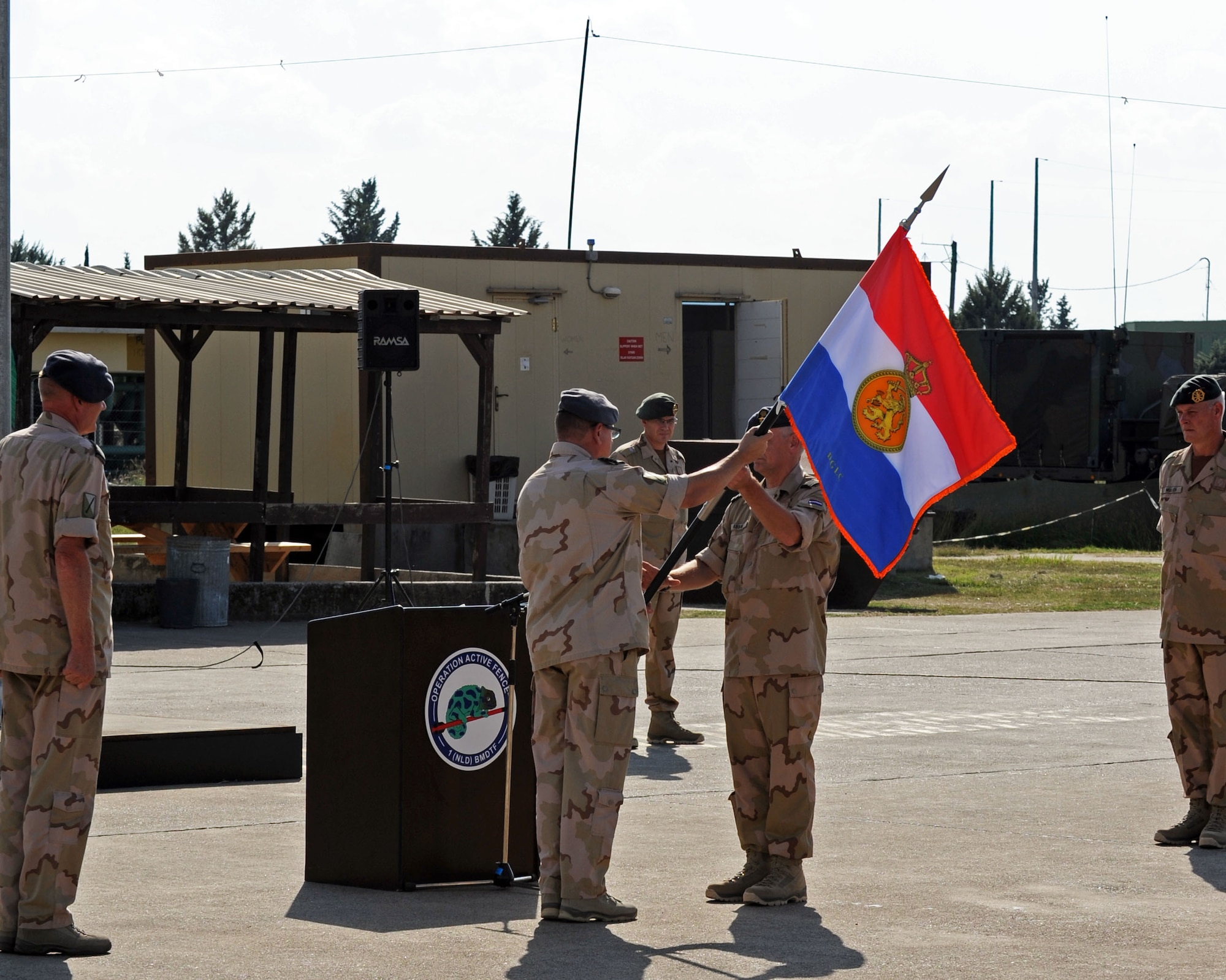 Dutch army Col. Peter Koning, outgoing 1st Netherlands Ballistic Missile Defense Task Force commander, passes a guidon to Dutch army Col. Erik Abma, incoming 1st NBMDTF commander Sept. 27, 2013, at Incirlik Air Base, Turkey. Abma will lead the third rotation of Dutch soldiers in continuing to provide air defense to the city of Adana, Turkey. (U.S. Air Force photo by Senior Airman Chase Hedrick/Released)