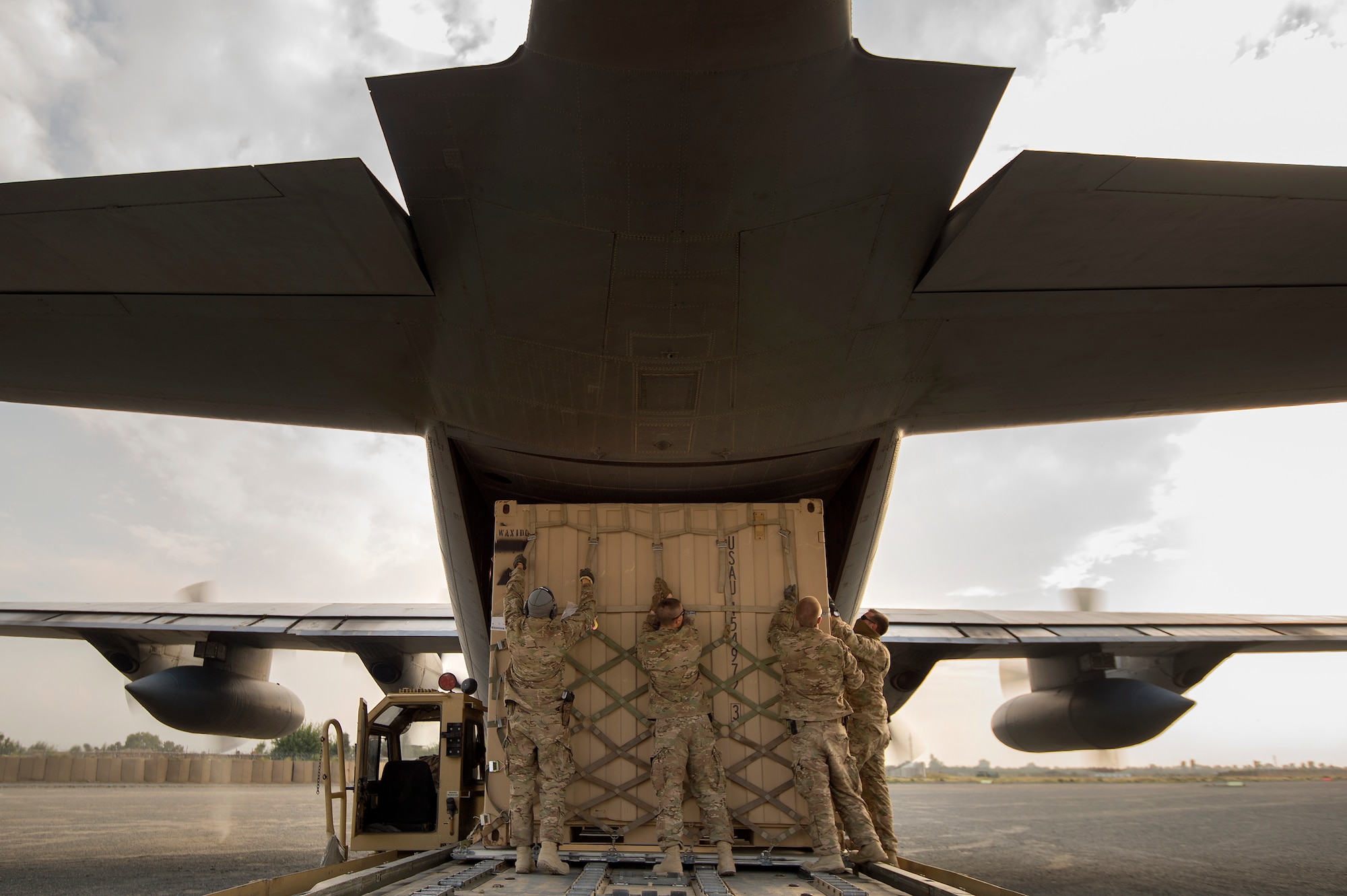 Tech. Sgt. Jonnedi Paule, Spc. Alexander Anderson, Staff Sgt. Daniel Hall and Staff Sgt. Andrey Benchea, 19th Movement Control Team aerial porters, prep a “tricon” shipping container for a 774th Expeditionary Airlift Squadron C-130 Hercules cargo plane at Forward Operating Base Salerno, Khost Province, Afghanistan, Sept. 22, 2013. The 19th MCT, a small squadron of Air Force surface movement controllers and aerial porters, have the herculean task of overseeing the vast majority of retrograde operations at FOB Salerno. Paule, a St. Paul, Minn. native, Hall, a Smith Valley, Nev. native and Benchea, a Phoenix, Ariz. native are all forward deployed from Travis Air Force Base, Calif. Anderson, hailing from Manvel, N.D. is a reservist from the 203rd Inland Cargo Transportation Company, Minn. (USAF Photo/Master Sgt. Ben Bloker)