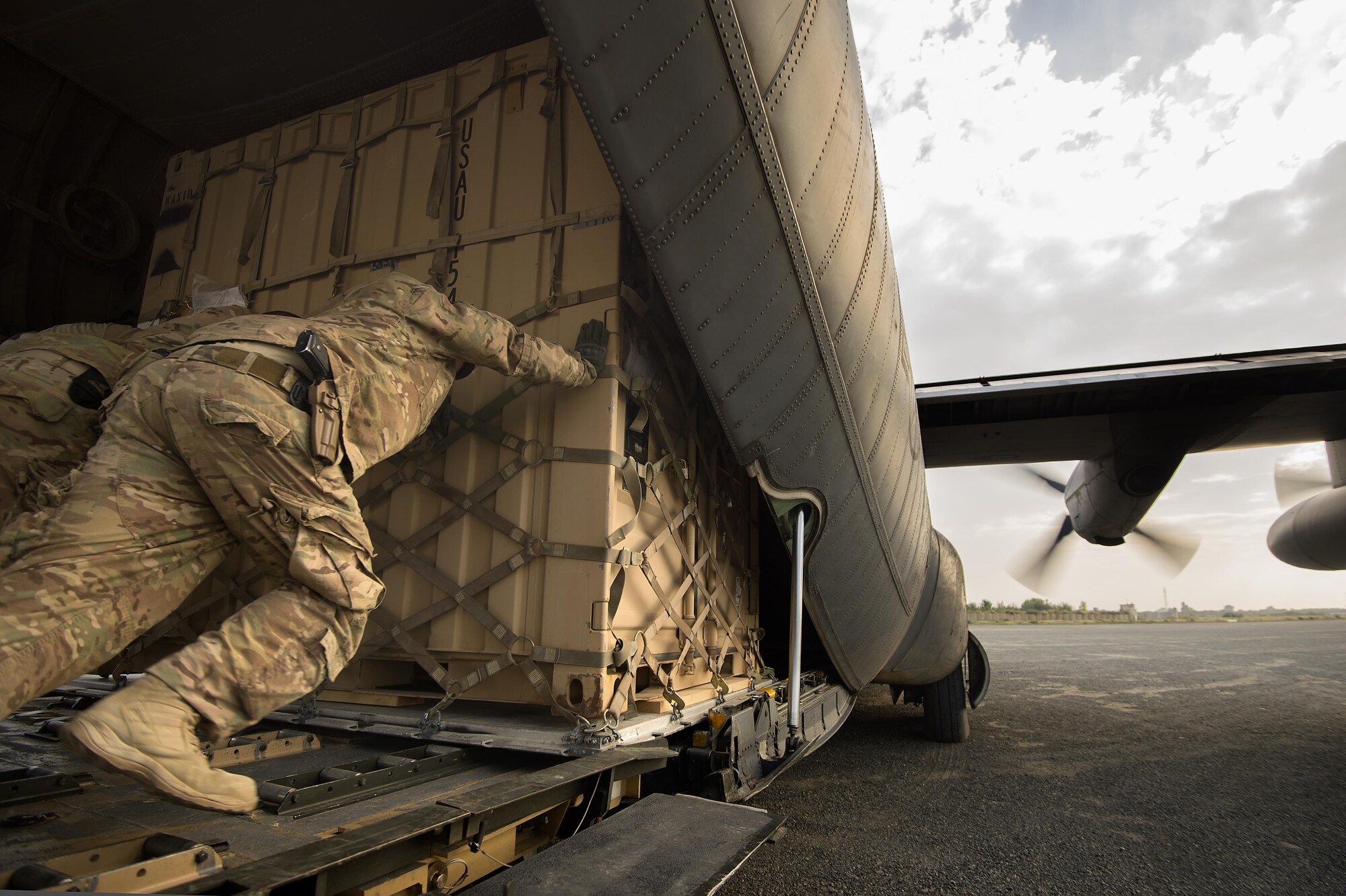 Staff Sgt. Daniel Hall, along with other 19th Movement Control Team aerial porters muscle a “tricon” shipping container into a 774th Expeditionary Airlift Squadron C-130 Hercules cargo plane at Forward Operating Base Salerno, Khost province, Afghanistan, Sept. 22, 2013. The 19th MCT, a small squadron of Air Force surface movement controllers and aerial porters, have the herculean task of overseeing the vast majority of retrograde operations at FOB Salerno. Hall, a Smith Valley, Nev. native is forward deployed from Travis Air Force Base, Calif. (USAF Photo/Master Sgt. Ben Bloker)

