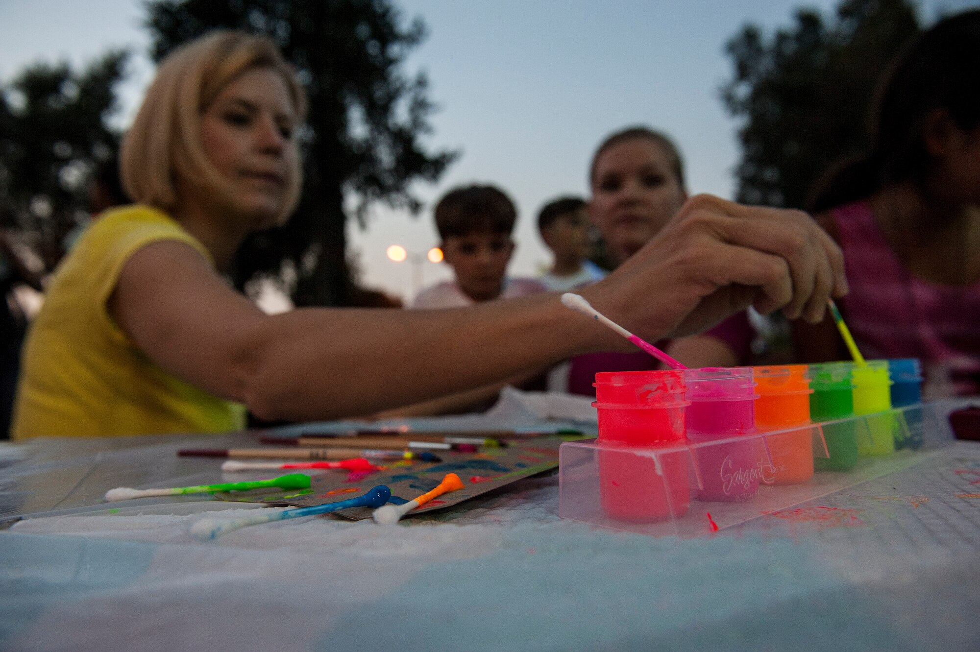 Capt. Krista Hutchinson, 39th Medical Operations Squadron physical therapists, dips her paintbrush into a pot of glow paint Sept. 30, 2013, at Incirlik Air Base, Turkey. Team Incirlik held a glow run for the Combined Federal Campaign Overseas, which is the annual workplace donation campaign for the five overseas unified combatant commands. (U.S. Air Force photo by Airman 1st Class Nicole Sikorski/Released)