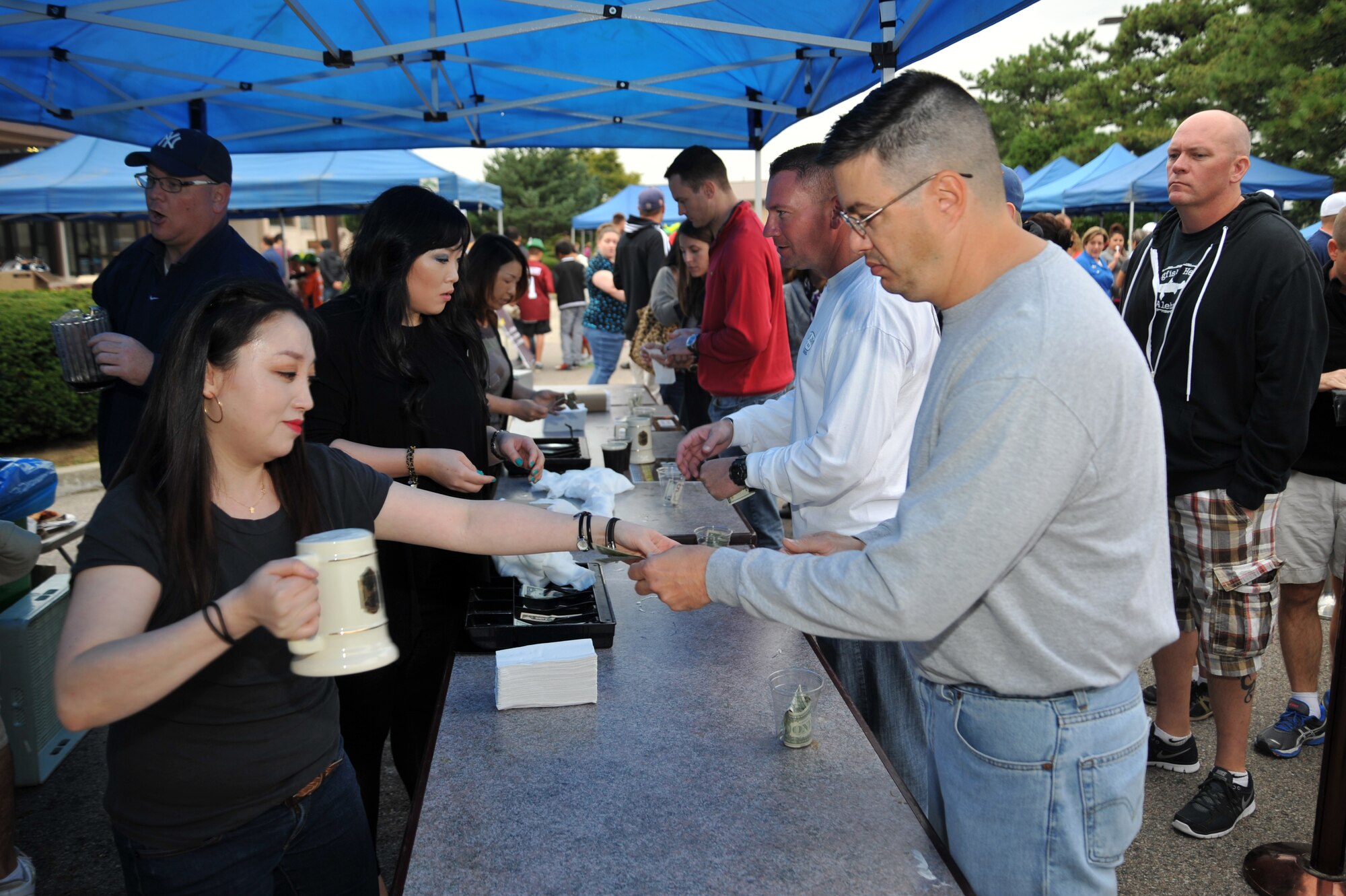 Members of the 51st Force Support Squadron members sell beer steins to guest during Oktoberfest at Osan Air Base, Republic of Korea, Sept. 28, 2013. The German stein is decorated differently each year and can be collected as a souvenir by guests who attend Oktoberfest events. (U.S. Air Force photo/Staff Sgt. Emerson Nuñez)