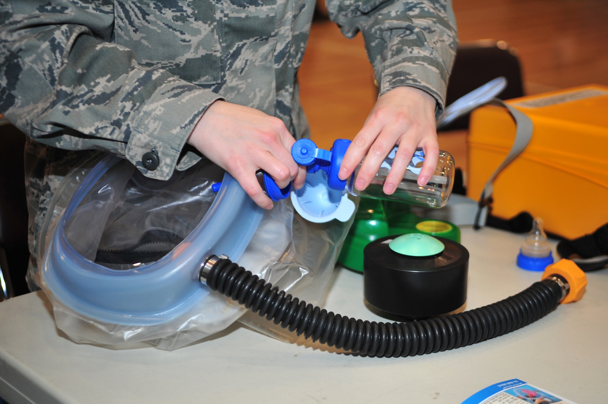 Staff Sgt. Cassandra Lane, 51st Civil Engineer Squadron emergency management journeyman, demonstrates how to attach an infant bottle to a dependent gas mask during a noncombatant evacuation operations exercise at Osan Air Base, Republic of Korea, Sept. 27, 2013. The instructional display was one of many highlights in the “comfort room,” in addition to a movie-viewing area, cots to sleep on, and literature and live assistance provided by the Osan Chaplain corps. (U.S. Air Force photo/Airman 1st Class Ashley J. Thum)