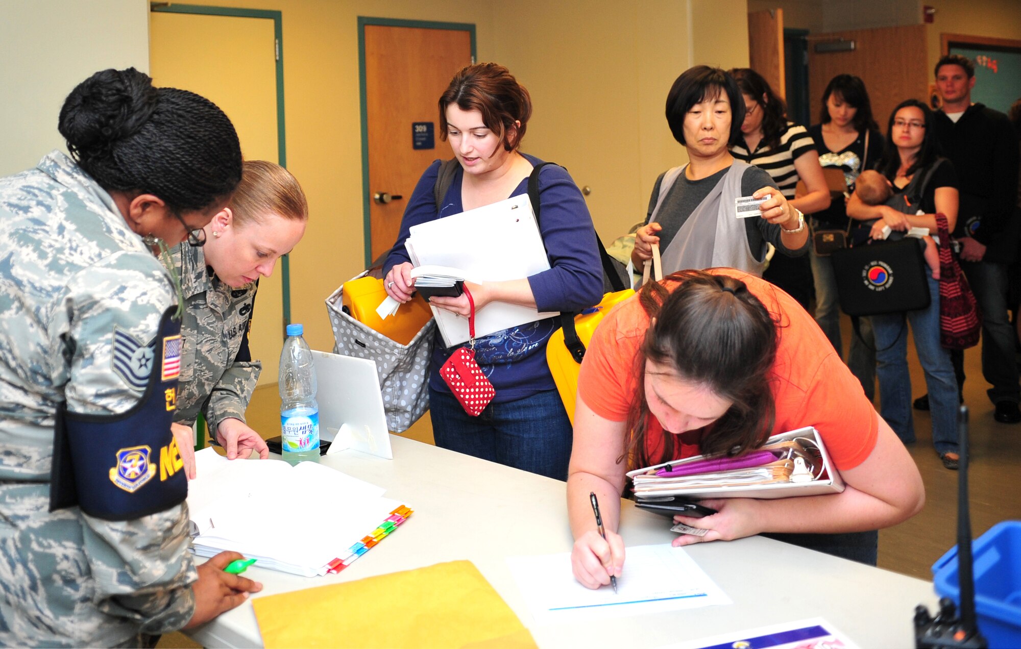 Tech. Sgts. Yolanda Heyward, 51st Comptroller Squadron quality assurance manager, and Jennifer Hunt, 51st Civil Engineer Squadron chief of unaccompanied housing, man the embarkation check point during a noncombatant evacuation operations exercise at Osan Air Base, Republic of Korea, Sept. 27, 2013. Embarkation was one of the last stops for exercise participants, and was a final measure to guarantee all passengers on the simulated mode of emergency transportation were accounted for. (U.S. Air Force photo/Airman 1st Class Ashley J. Thum)