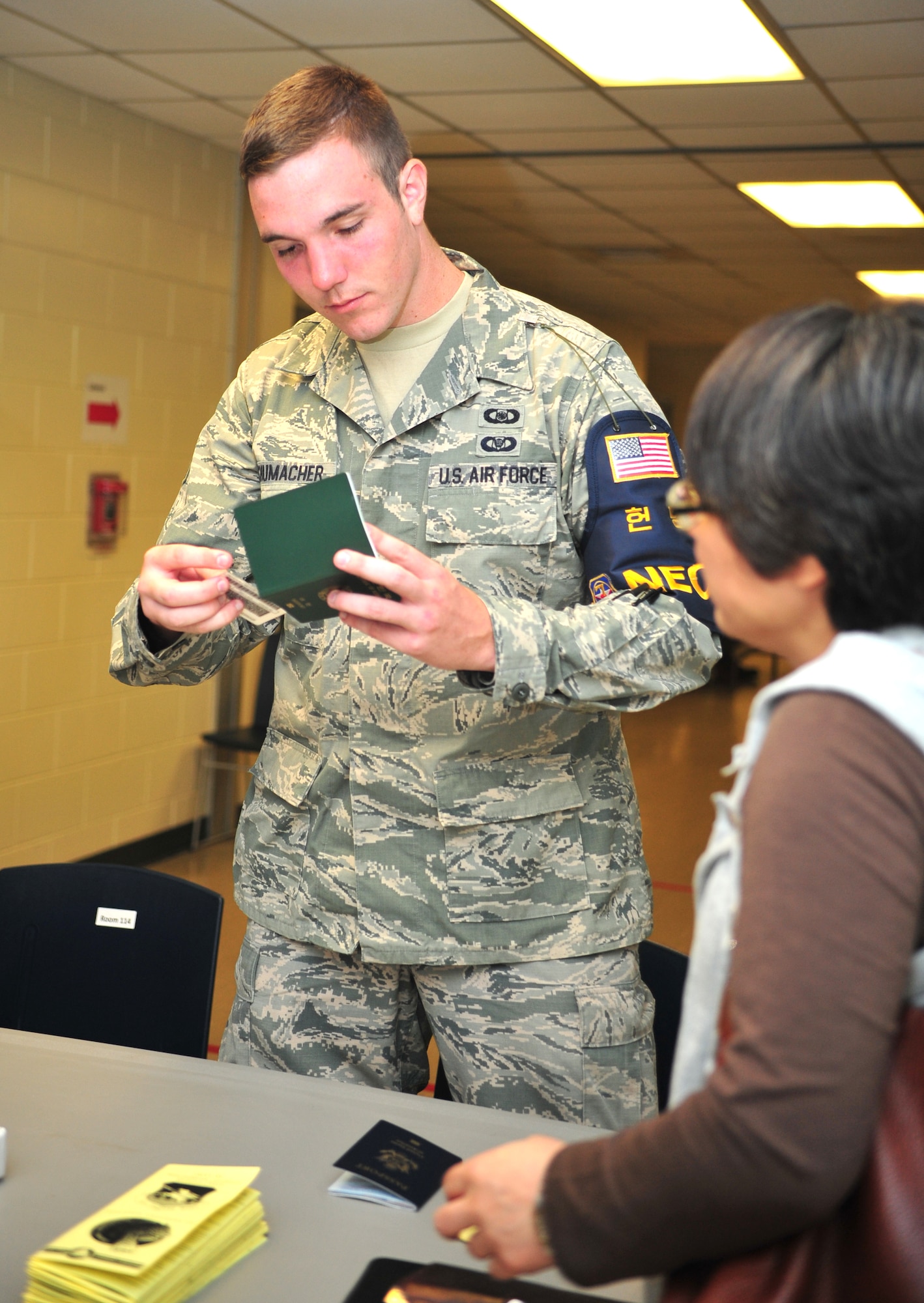 Staff Sgt. Jacob Schumacher, 621st Air Control Squadron weapons director, verifies the identity of a noncombatant evacuation operations exercise participant at Osan Air Base, Republic of Korea, Sept. 27, 2013. At least one representative from each household with a noncombatant was mandated to attend the event in an effort to maintain maximum readiness across the base. Representatives from approximately 100 households practiced the process of a peninsula evacuation on the third day of the exercise. (U.S. Air Force photo/Airman 1st Class Ashley J. Thum)