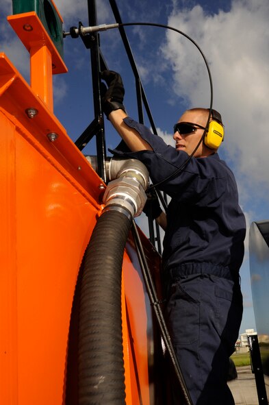 U.S. Air Force Airman 1st Class Travis Drouin, 18th Civil Engineer Squadron heavy equipment operator, inspects an ultra high-pressure water system while it removes rubber deposits on a runway on Kadena Air Base, Japan, Sept. 30, 2013. If left alone, rubber deposits can cause the runway to become extremely slippery and greatly reduce pilot visibility of the centerline, making it harder to land safely. (U.S. Air Force photo by Senior Airman Marcus Morris)