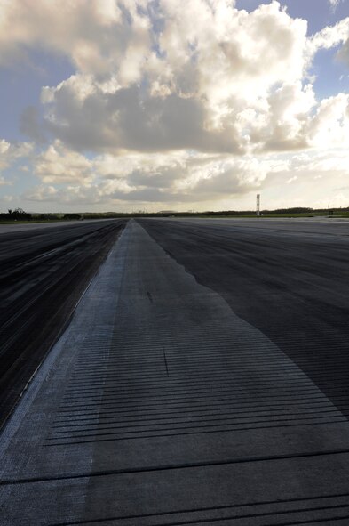 A clean strip of runway is left after 18th Civil Engineer Squadron heavy equipment operators finish their first pass with a rubber and stripe removal machine. Rubber deposits can cause the runway to become extremely slippery and greatly reduce pilot visibility of the centerline, making it harder to land safely.  (U.S. Air Force photo by Senior Airman Marcus Morris)