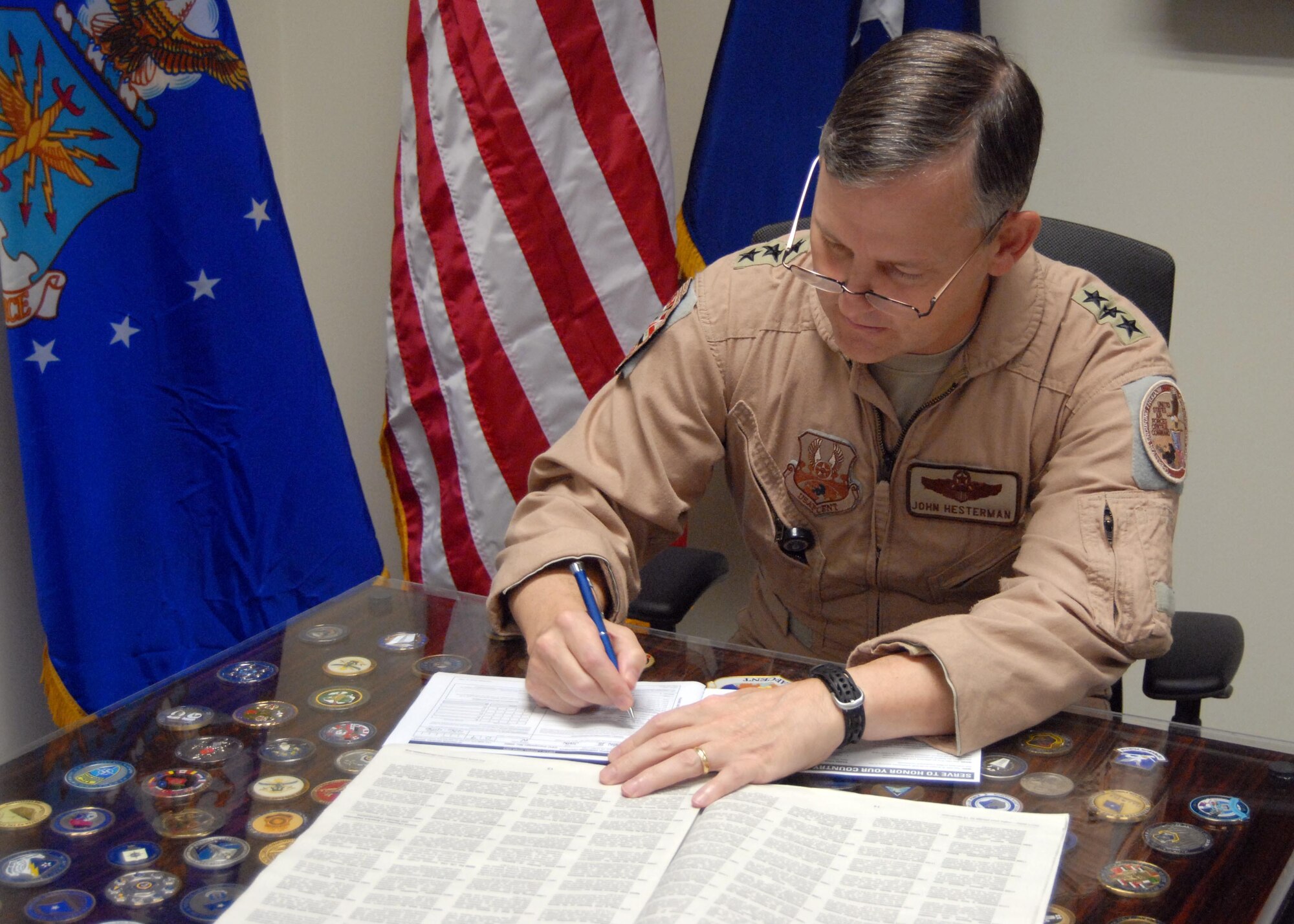 Lt. Gen. John Hesterman, Air Forces Central Command commander, signs a Combined Federal Campaign pledge card Sept. 22, 2013 at the Combined Air and Space Operations Center at an undisclosed location in Southwest Asia.  The CFC is an annual fundraising program designed to support and promote philanthropy through a program that is employee-focused, cost efficient and effective in providing all Federal employees the opportunity to improve the quality of life for all. “While we are here sacrificing ourselves, it is important to remember and contribute to those who may be sacrificing all over,” said Hesterman. (U.S. Air Force courtesy photo)