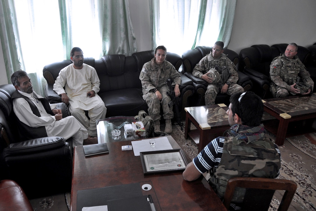 U.S. Army Capt. Jennifer Leathers, center, discusses current projects and planning with Frhadi Foroq, second from left, advisor for the Directorate of Agriculture, Irrigation and Livestock, during a meeting in Farah City, Afghanistan, Sept. 28, 2013. Leathers is assigned to Provincial Reconstruction Team Farah.