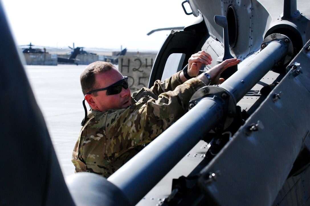 U.S. Army Chief Warrant Officer 2 Mike Black performs a preflight inspection on a UH-60M Black Hawk helicopter before a personnel movement mission on Forward Operating Base Shank, Afghanistan, Sept. 25, 2013. Black, a pilot, is assigned to Company C, 2nd Battalion, 10th Combat Aviation Brigade, Task Force Falcon.