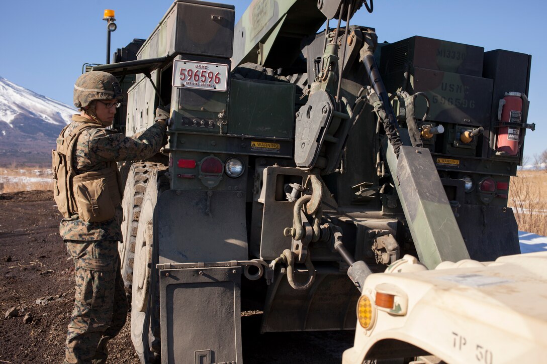 Lance Cpl. Dennon L. Audette controls the towing winch of an MK36 wrecker 7-ton truck at the North Fuji Maneuver Area, Combined Arms Training Center Camp Fuji, January 29 during Artillery Relocation Training Program 13-4. During ARTP 13-4, Marines with 3rd Battalion, 12th Marine Regiment, relied on Motor Transport Maintenance Section to keep more than 100 vehicles operational. Audette is a motor transportation wrecker operator with Headquarters Battery, 3rd Bn., 12th Marines, 3rd Marine Division, III Marine Expeditionary Force. 