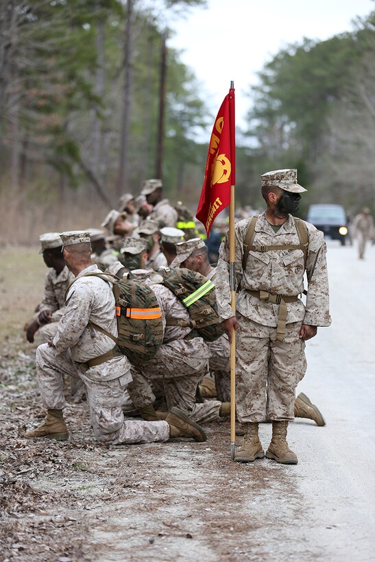 Private Margarito J. Deniz carries the Cherry Point Center for Naval Aviation Technical Training's unit guide-on during a six-mile hike at Cherry Point March 28, 2014. The Cherry Point CNATT Marines and Sailors took to the field as part of the school's implementation of the commandant and sergeant major of the Marine Corps' Reawakening campaign. The noncommissioned officer planned and led event included a six-mile hike, presentations from Marines with Cherry Point's 2nd Low Altitude Air Defense Battalion, a field meet and a field mess night. Deniz is a student at CNATT.