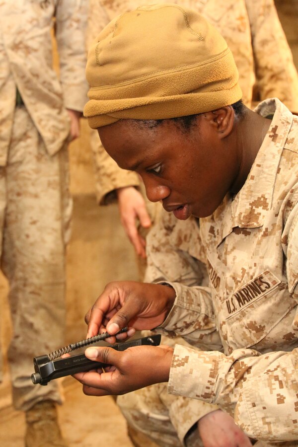 Cpl. Donna Occuis, supply wearhouse clerk, assembles an M-9 service pistol during a training event aboard Marine Corps Base Quantico on March 28, 2014. The challenge was part of an eight-station training event that Headquarters and Service Co. Marines participated in. 