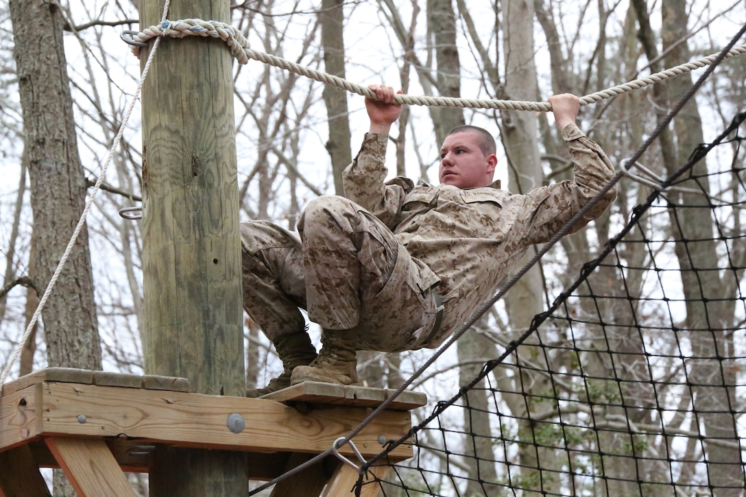 Cpl. Philip Jiminez, administrative specialist, navigates the Tarzan Course, a mid-air ropes course, at the Officer Candidates School aboard Marine Corps Base Quantico on March 28, 2014. The challenge was part of an eight-station training event that Headquarters and Service Co. Marines participated in.