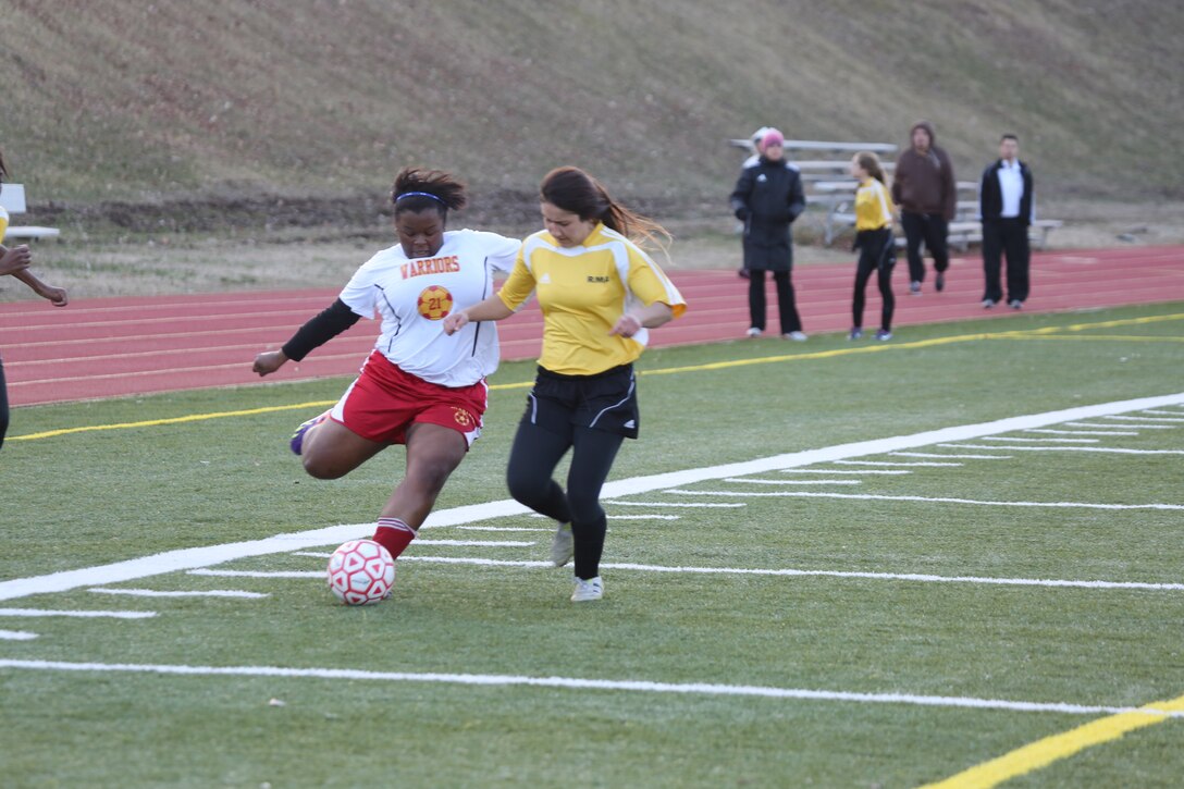 Aonjhne, a sophomore for the Quantico Middle/High School girls soccer team, tries to pass the ball across the field during a game against the Yellow Jackets of Randolph-Macon Academy from Ashland on March 27, 2014, at Butler Stadium. Quantico pushed hard the whole game and beat Randolph-Macon for the first time in more than a decade, with a score of 1-0.
