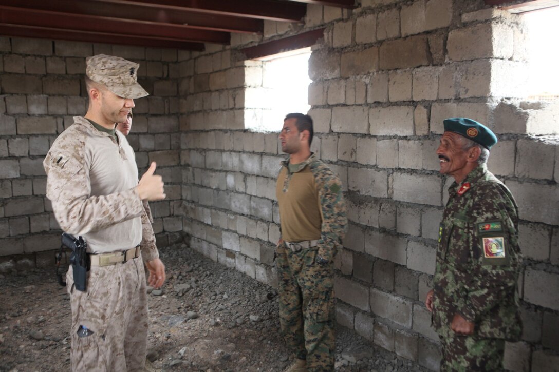 Navy Lt. j.g. James M. Nicholson, left, Afghan National Army, senior medical advisor with Security Force Assistant Advisor Team 2-215, speaks to Lt. Col. Abdullah Sultani, right, lead medic with the 2nd Brigade, Afghan National Army, aboard Forward Operating Base Nolay, Helmand province, Afghanistan, March 21, 2014. Nicholson, 33, from St. Petersburg, Fla., visits the ANA medics daily to offer advice and see the progress they are making. (USMC photo by Cpl. Joshua Young)