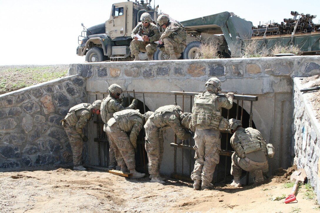 U.S. Army soldiers with the 65th Engineer Battalion install culvert denial systems along Highway 1 in Helmand province, Afghanistan, March 24, 2014. The system is comprised of two metal-bar grates that are placed at either ends of the culvert and held together by tension force cables, with an anti-tampering device secured to the grates. The device can detect any type of disturbance from vibrations to heat and will initiate a camera to record any tampering with the system.