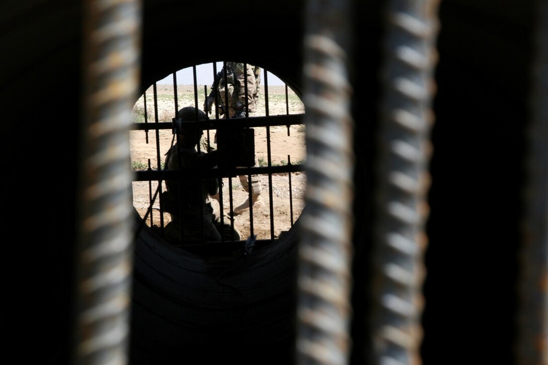 A U.S. Army soldier with the 65th Engineer Battalion installs culvert denial systems along Highway 1 in Helmand province, Afghanistan, March 24, 2014. The system is comprised of two metal-bar grates that are placed at either end of the culvert and held together by tension force cables, with an anti-tampering device secured to the grates. The device can detect any type of disturbance from vibrations to heat and will initiate a camera to record any tampering with the system.