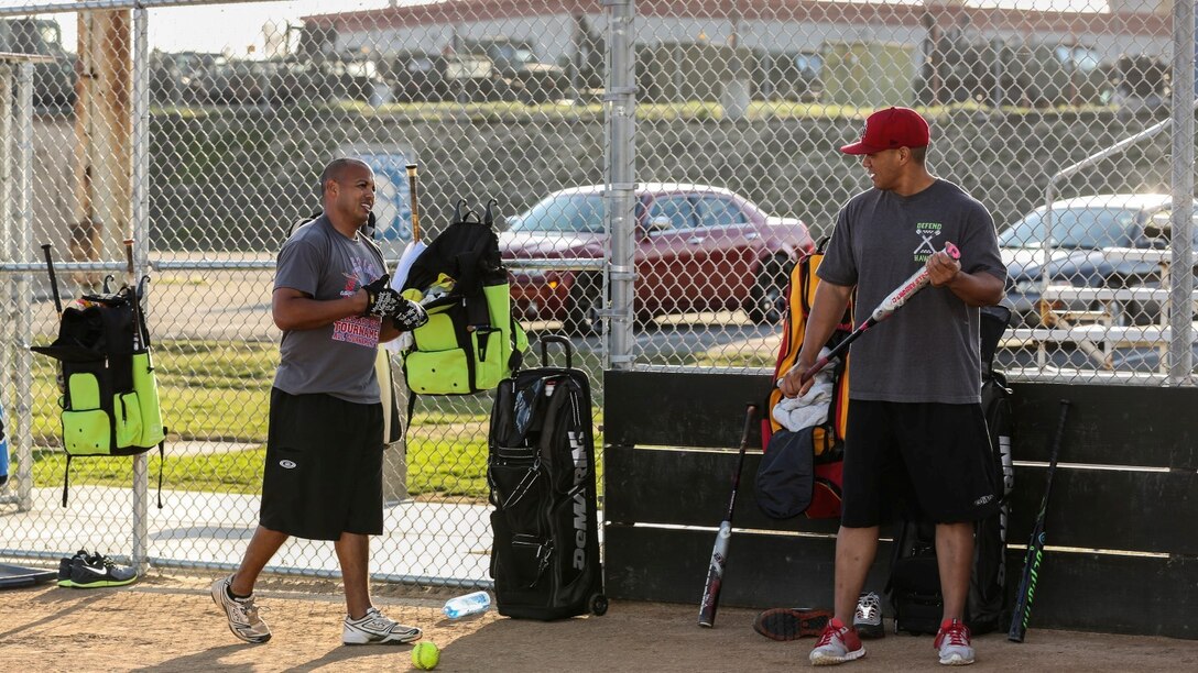 Petty Officer 2nd Class Gabriel Cisneros, left, religious program specialist, 15th Marine Expeditionary Unit, gives a teammate a few pointers on his swing during a softball practice aboard Camp Pendleton, Calif., March 13, 2014. Cisneros, 36, is from Diamond Bar, Calif.  (U.S. Marine Corps video by Cpl. Emmanuel Ramos/Released)