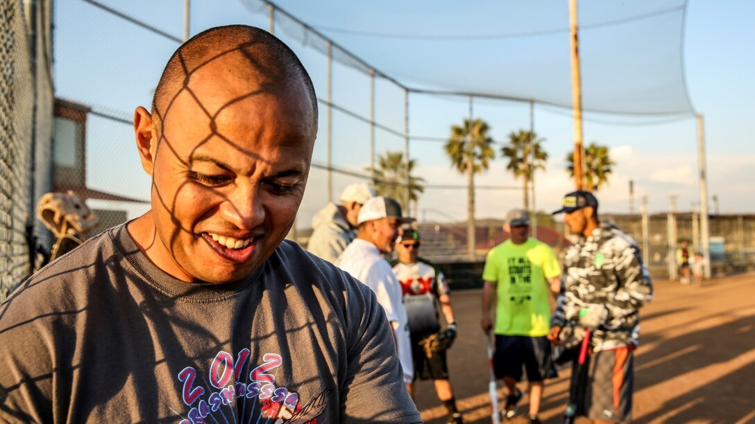 Petty Officer 2nd Class Gabriel Cisneros, religious program specialist, 15th Marine Expeditionary Unit, jokes with teammates after softball practice aboard Camp Pendleton, Calif., March 13, 2014. Cisneros, 36, is from Diamond Bar, Calif.  (U.S. Marine Corps video by Cpl. Emmanuel Ramos/Released)