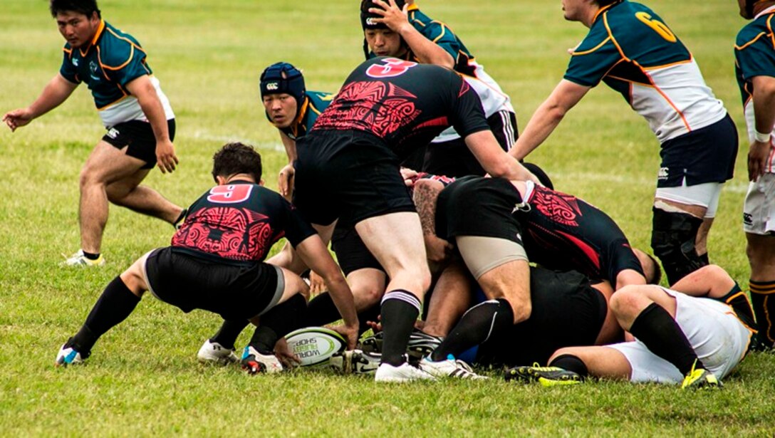 U.S. Marine Capt. Curt Williamson, crouching left, recovers the ball March 29 during a rugby match between the Camp Hansen Kaiju and Japan Self-Defense Force Naha Rugby Football Club on Camp Hansen. “Sports bring people together and give us a chance to get to know one another – foster friendship. Rugby in particular grows great relationships, and we’re looking forward to continuing to build a solid relationship with the Naha RFC,” said Williamson, an assistant intelligence officer with 31st Marine Expeditionary Unit, III Marine Expeditionary Force. 