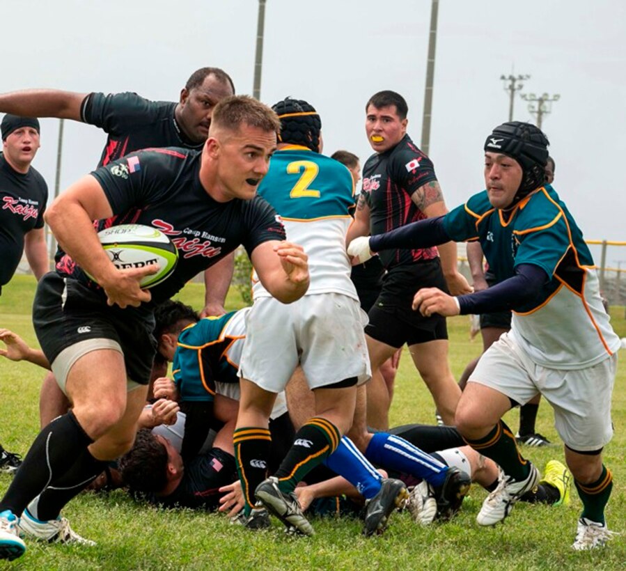 U.S. Marine Capt. Andrew Bohn breaks away from a tackle March 29 during a rugby match on Camp Hansen. In rugby, a player can carry the ball as long as he stays on his feet; the moment the player falls to the ground, he must release the ball. Bohn is a platoon commander with 3rd Reconnaissance Battalion, 3rd Marine Division, III Marine Expeditionary Force. 
