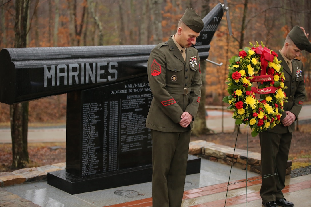 Two Marines bow their heads during the memorial dedication ceremony for the Marine Light Helicopter Squadron 167 and its successor, Marine Light Attack Helicopter Squadron 167, on March 29, 2014. The dedication ceremony brought together Marines both active and retired to honor their brothers who gave their lives in combat. 