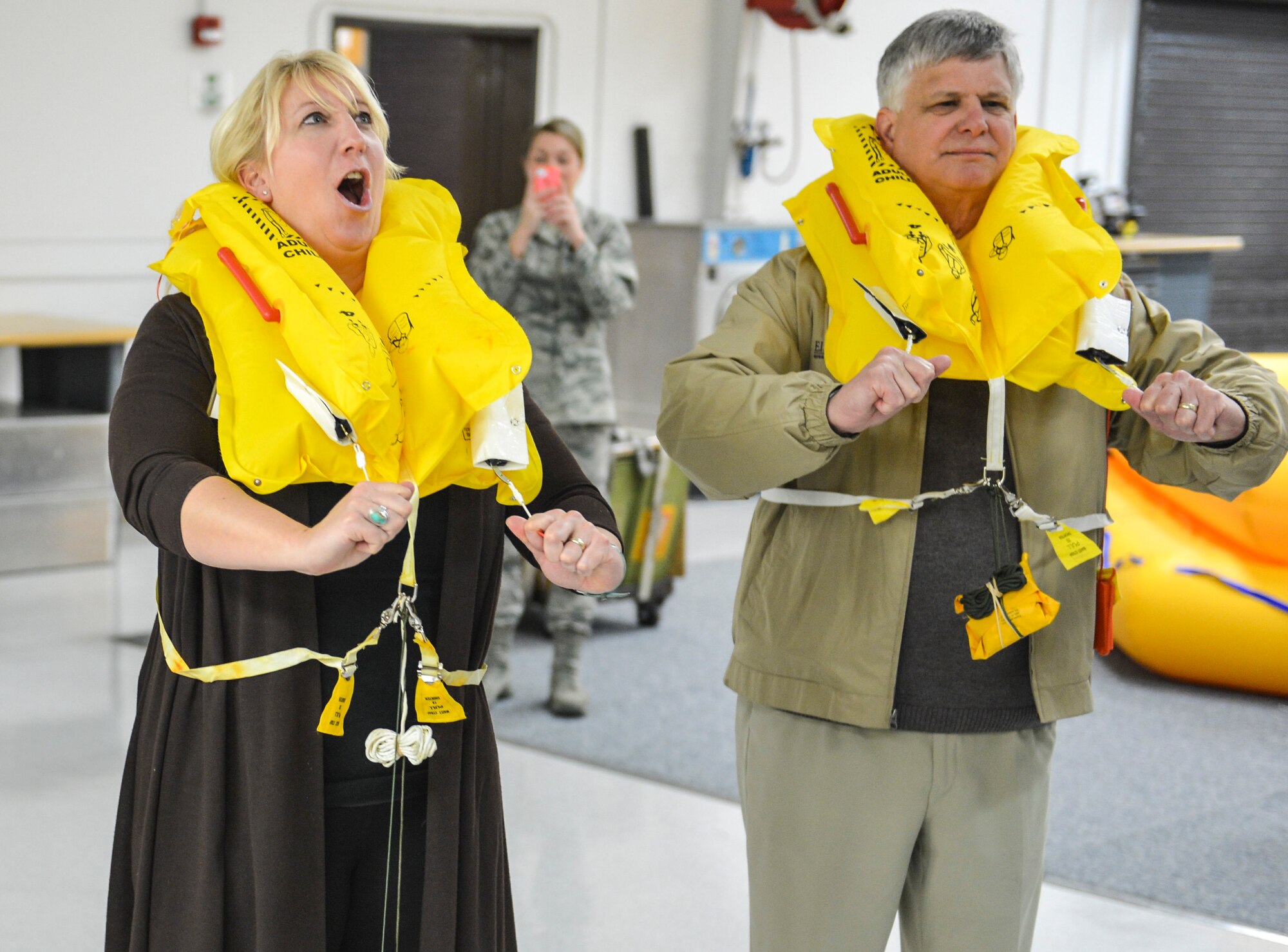 Tracy Peacock, American Red Cross Mount Rainier Chapter executive, finds out first-hand how fast personal floatation devices inflate March 28, 2014, at the aircrew flight equipment demonstration during the 2014 Fly-Away Civic Leader tour at Joint Base Lewis-McChord, Wash. This year’s tour stopped by the 62nd AFE shop to learn about parachutes, night vision goggles and water survival prior to heading to Travis Air Force Base, Calif. (U.S. Air Force photo by Staff Sgt. Russ Jackson)