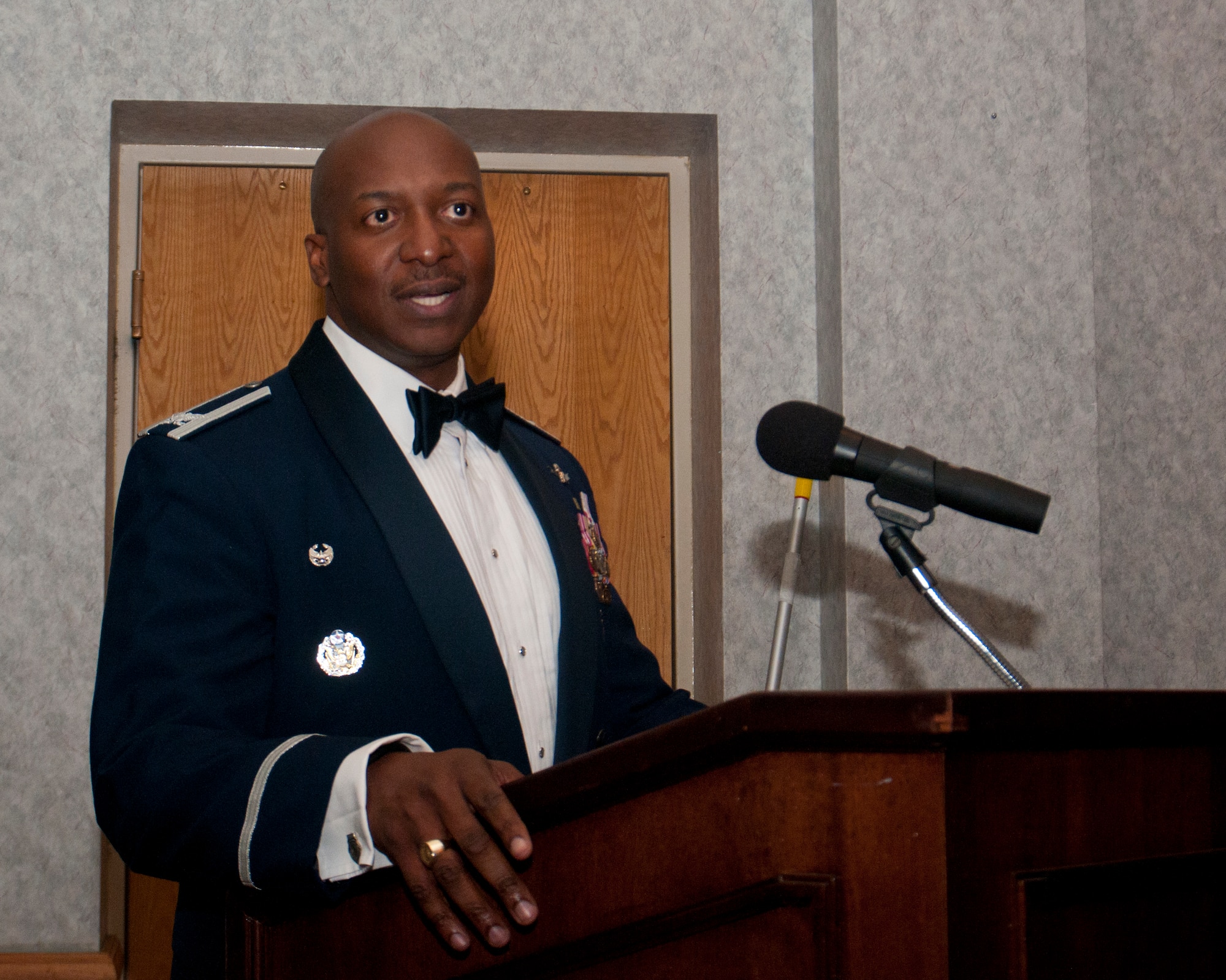 Col. Carl Jones, 90th Missile Wing vice commander, speaks at an Airman Leadership School graduation while “leading from the front” with a mustache that inspired the graduates March 26, 2014, in the Trail’s End Club. (U.S. Air Force photo by Airman 1st Class Jason Wiese)